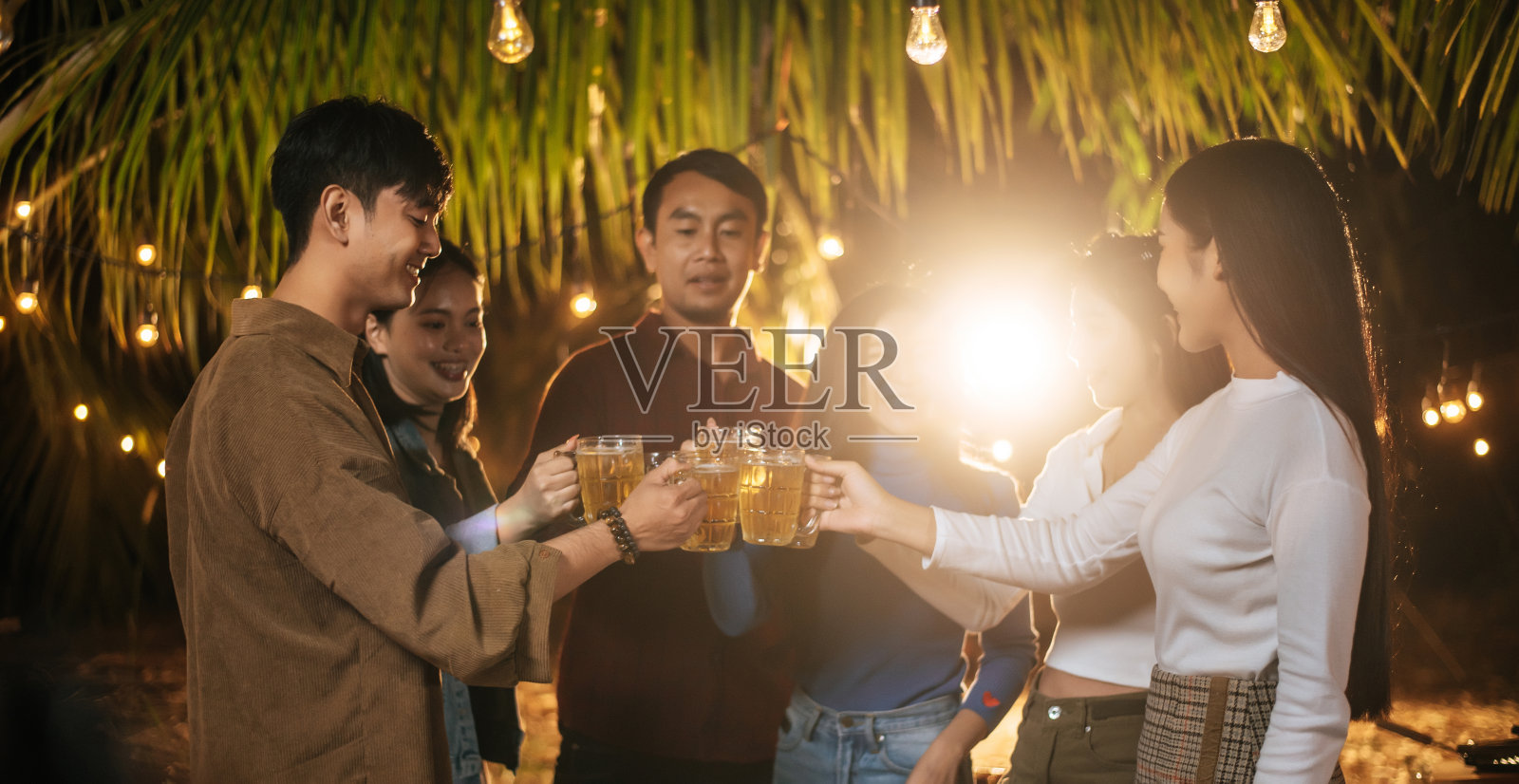 快乐的亚洲朋友一起聚餐的肖像-年轻人在户外举杯喝啤酒-人，食物，饮料的生活方式，新年庆祝的概念。照片摄影图片
