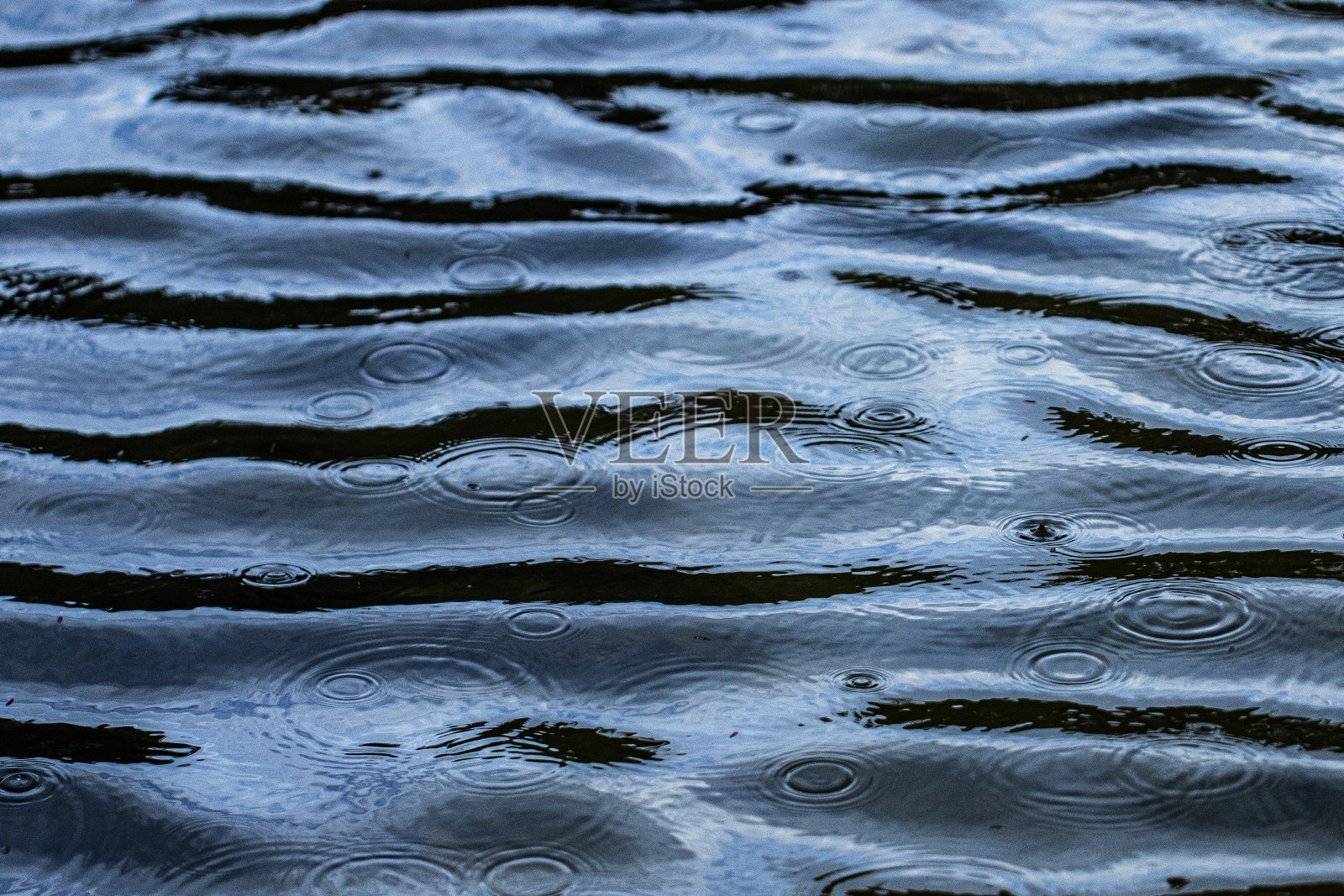 暴雨期间，水滴在湖中形成了一个自然的图案照片摄影图片