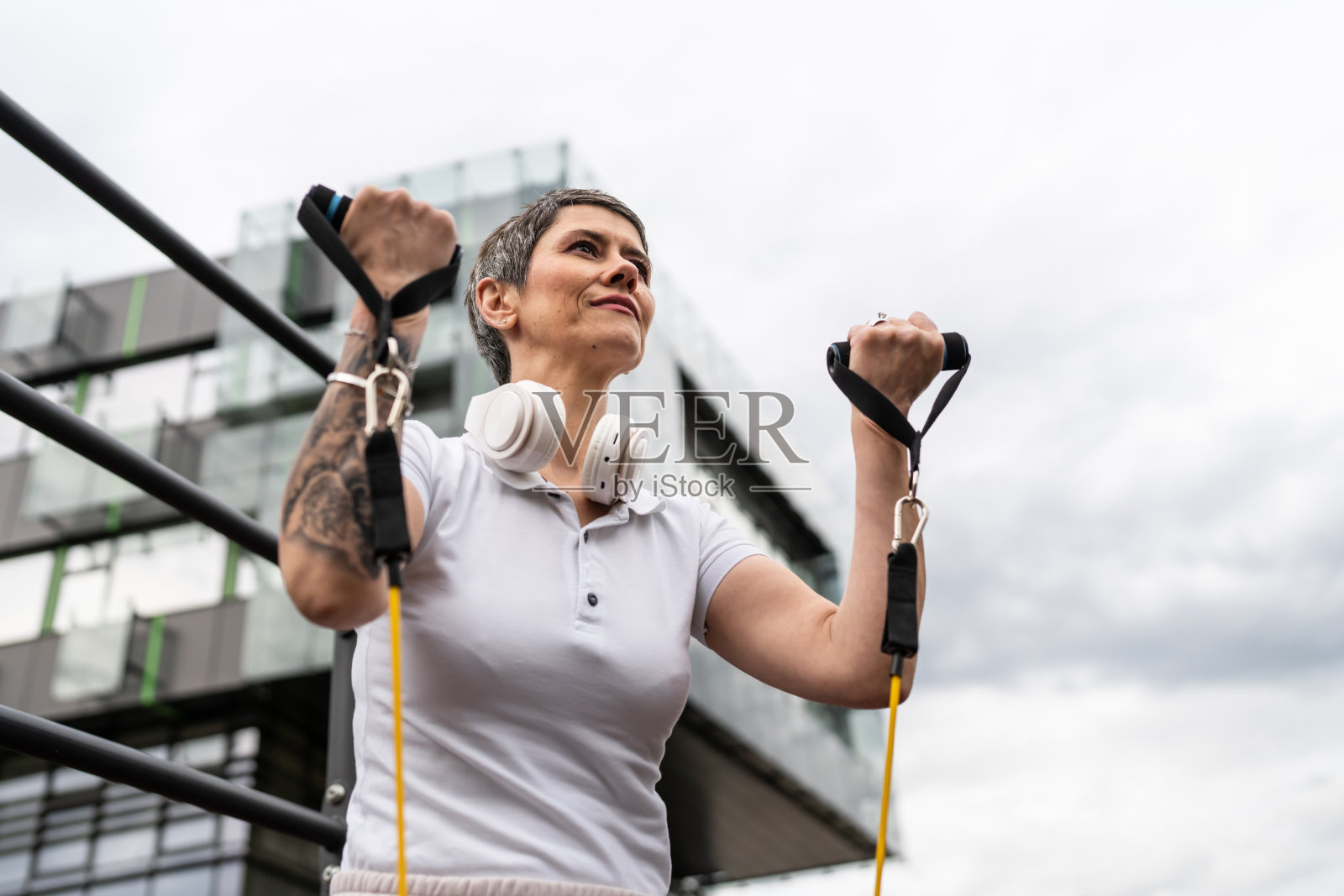 成熟的高级妇女训练户外公园健身房与阻力带照片摄影图片