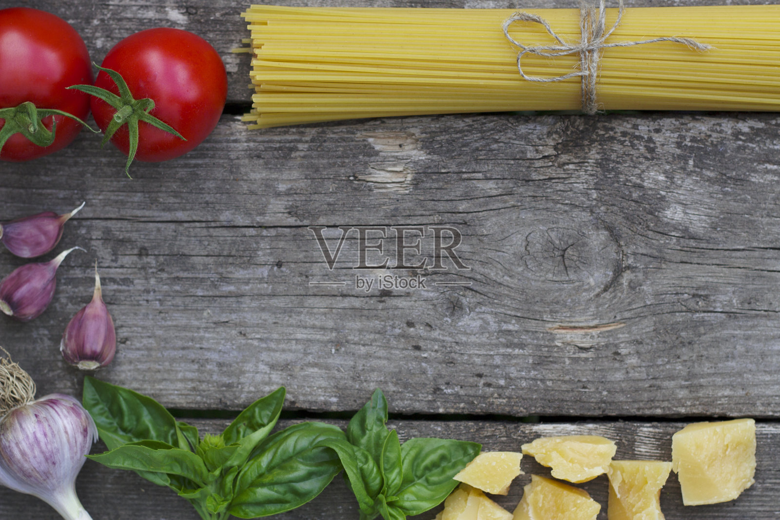 旧木桌上放着意大利面和煮酱用的蔬菜照片摄影图片