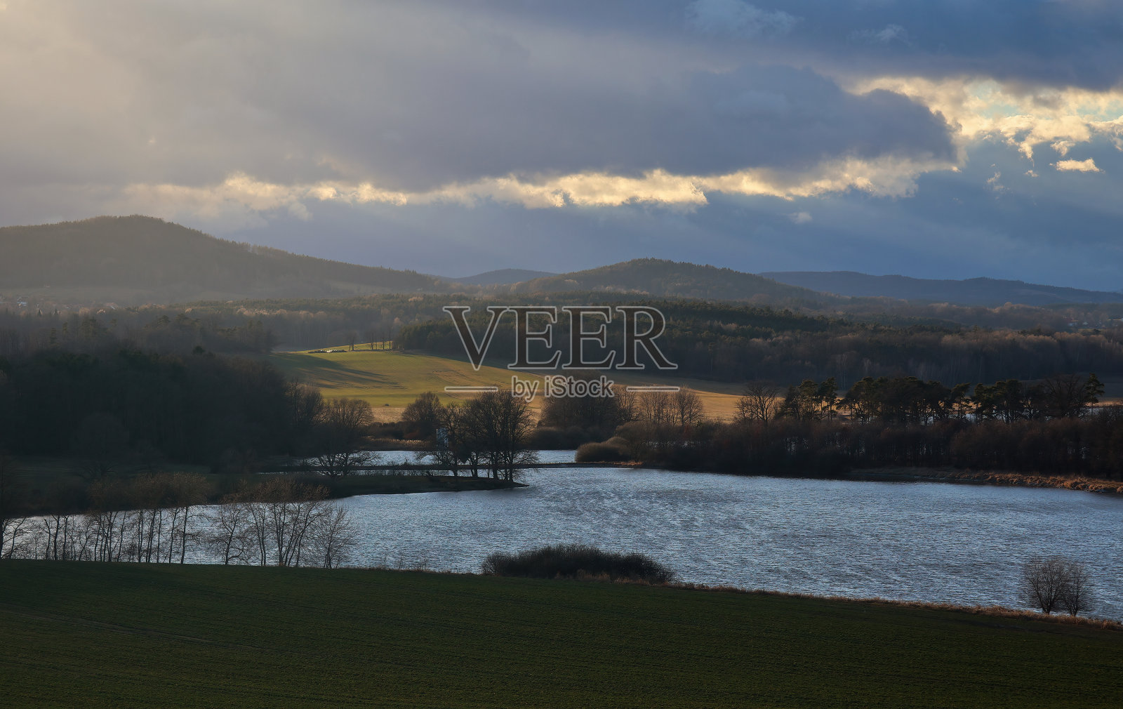 夕阳映在池塘上，远山映着阳光。早春捷克风光照片摄影图片