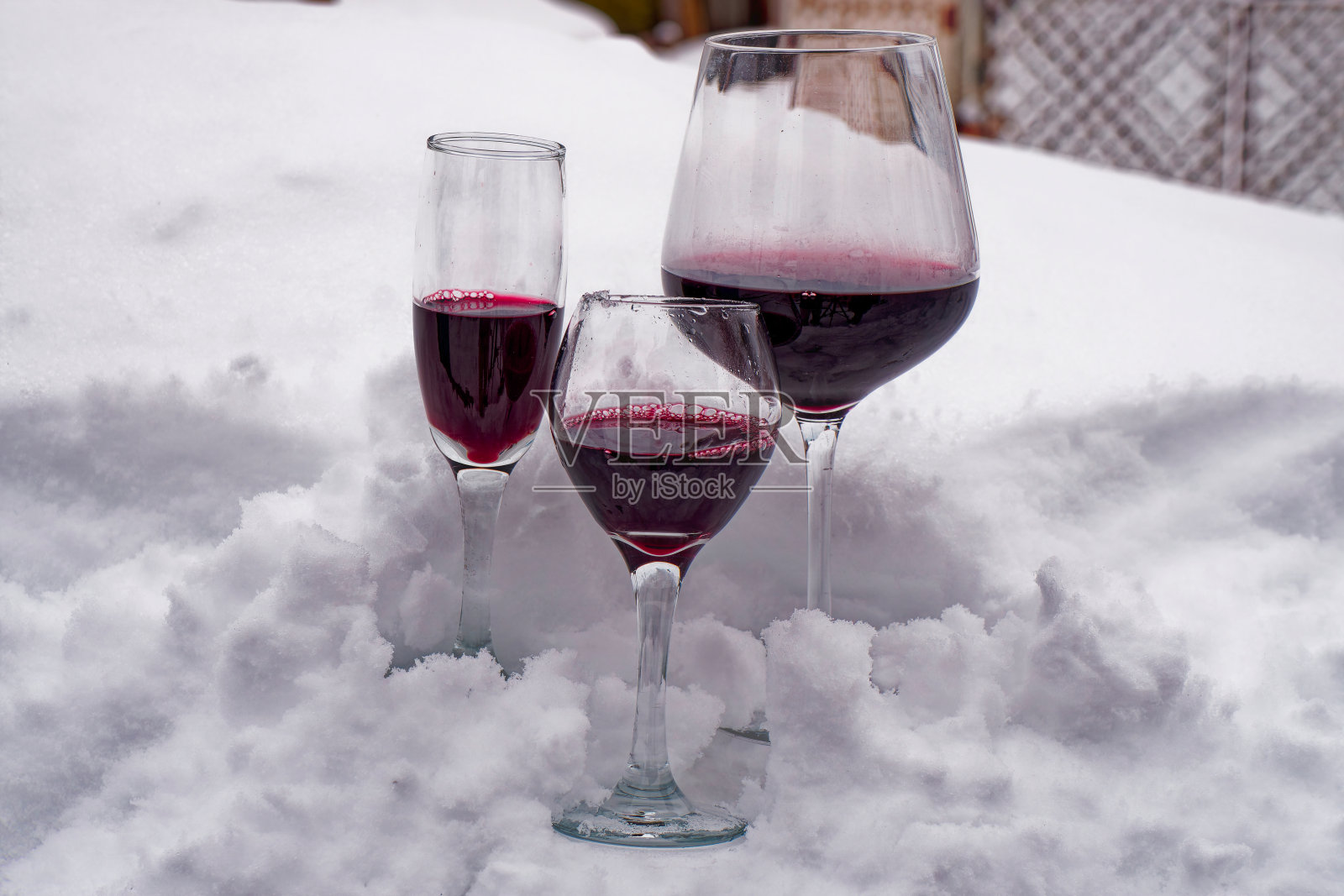 在隆冬的新雪中，喝上几杯可爱的红酒。照片摄影图片