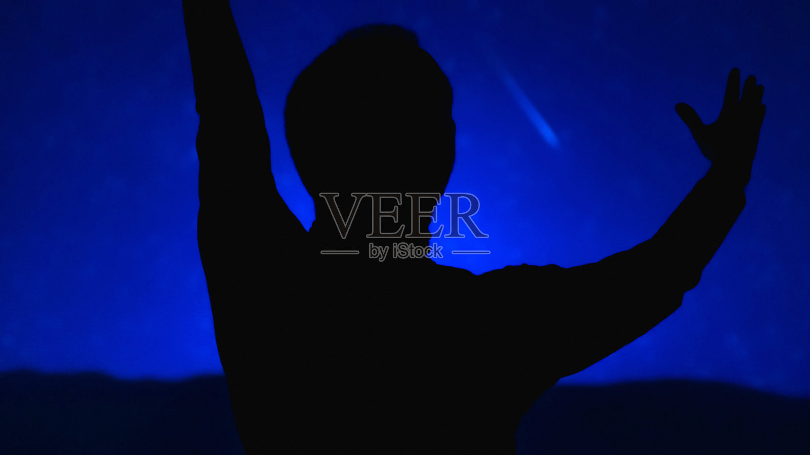 一个男人的剪影银河星空。照片摄影图片