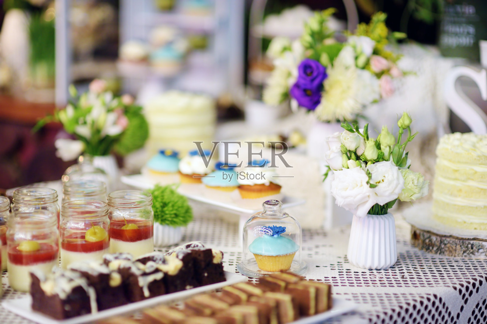 在一些节日活动中，在甜蜜的桌子上装饰彩色纸杯蛋糕照片摄影图片