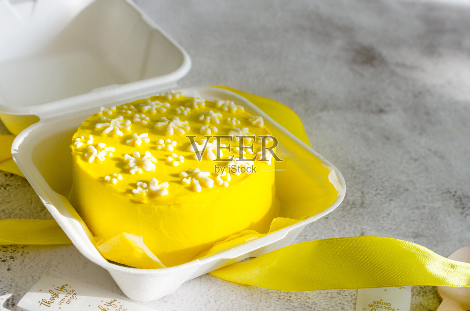 时尚的便当蛋糕，可爱的花朵装饰在明亮的背景。照片摄影图片