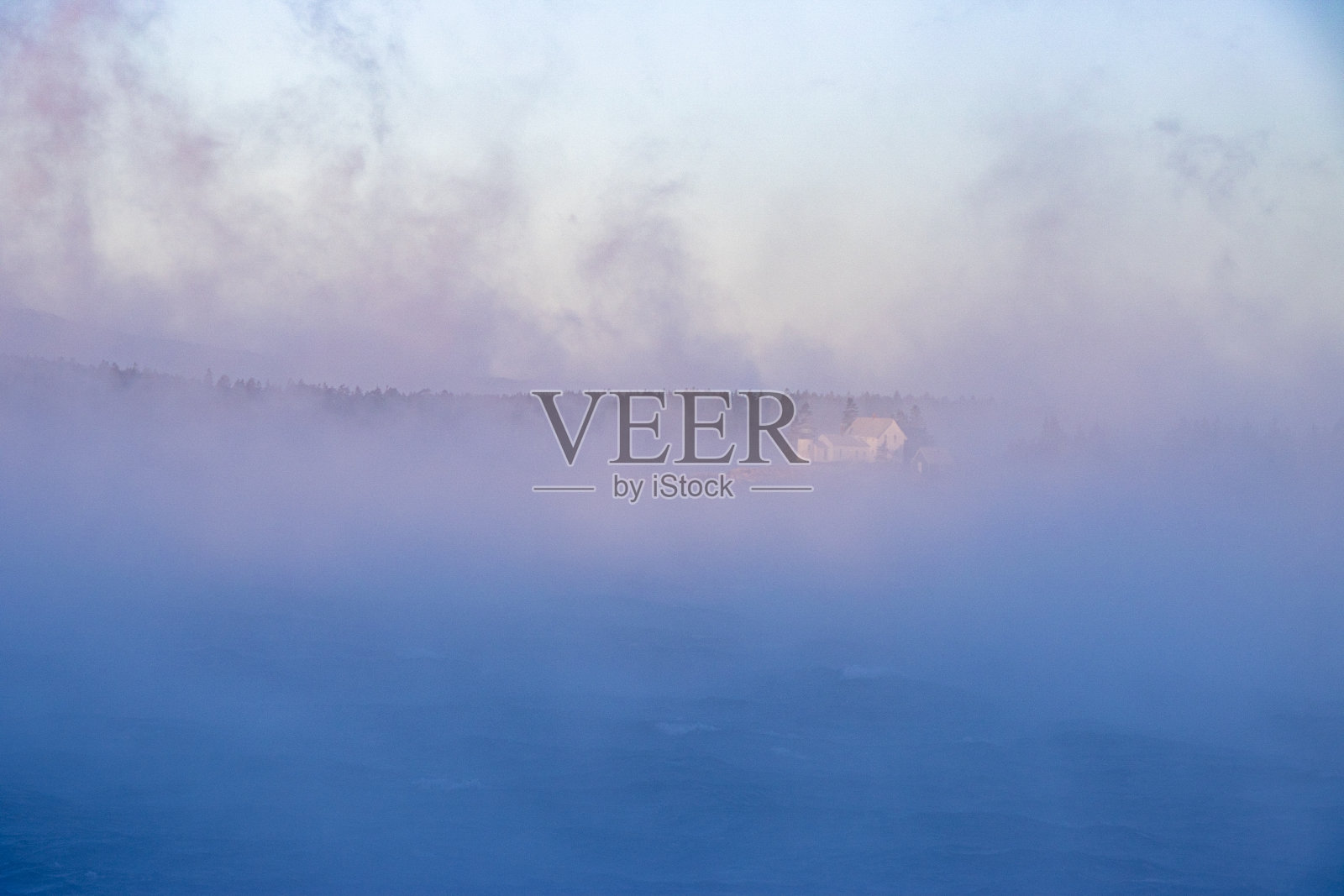 灯塔在黎明透过海雾照片摄影图片