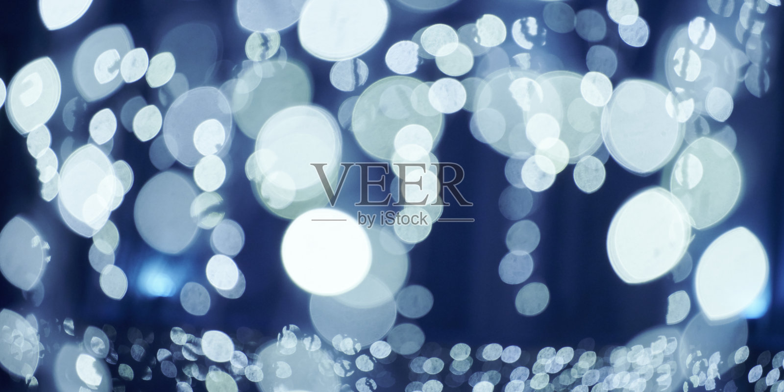 蓝色灯光散景从圣诞节日花环，模糊的节日背景，抽象的灯照片摄影图片