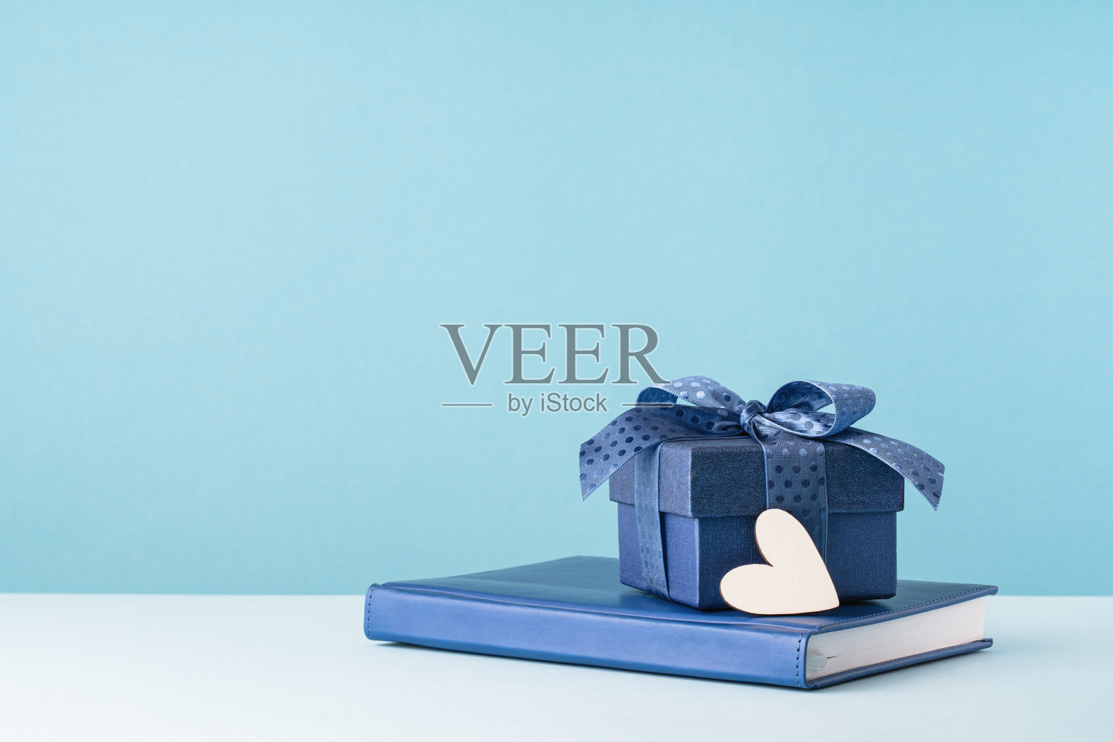 一个礼盒，议程上有一个蓝色的蝴蝶结和白色的心照片摄影图片