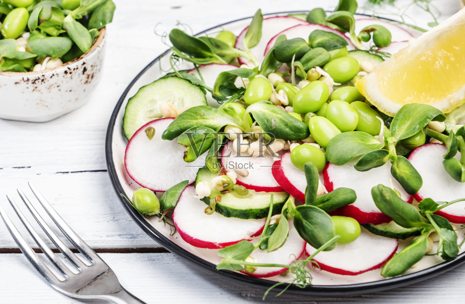 春季素食沙拉，有萝卜，黄瓜，豌豆，向日葵和豆芽，毛豆。健康的饮食食品。俯视图照片摄影图片