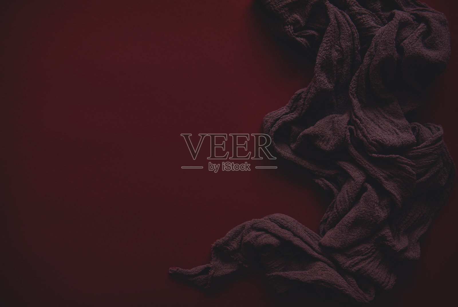 红色的背景是黑色的纹理织物，象征着人类与邪恶的斗争。红色是斗争中流出的鲜血，黑色是邪恶。带有雾霾效果的照片。文本空间照片摄影图片