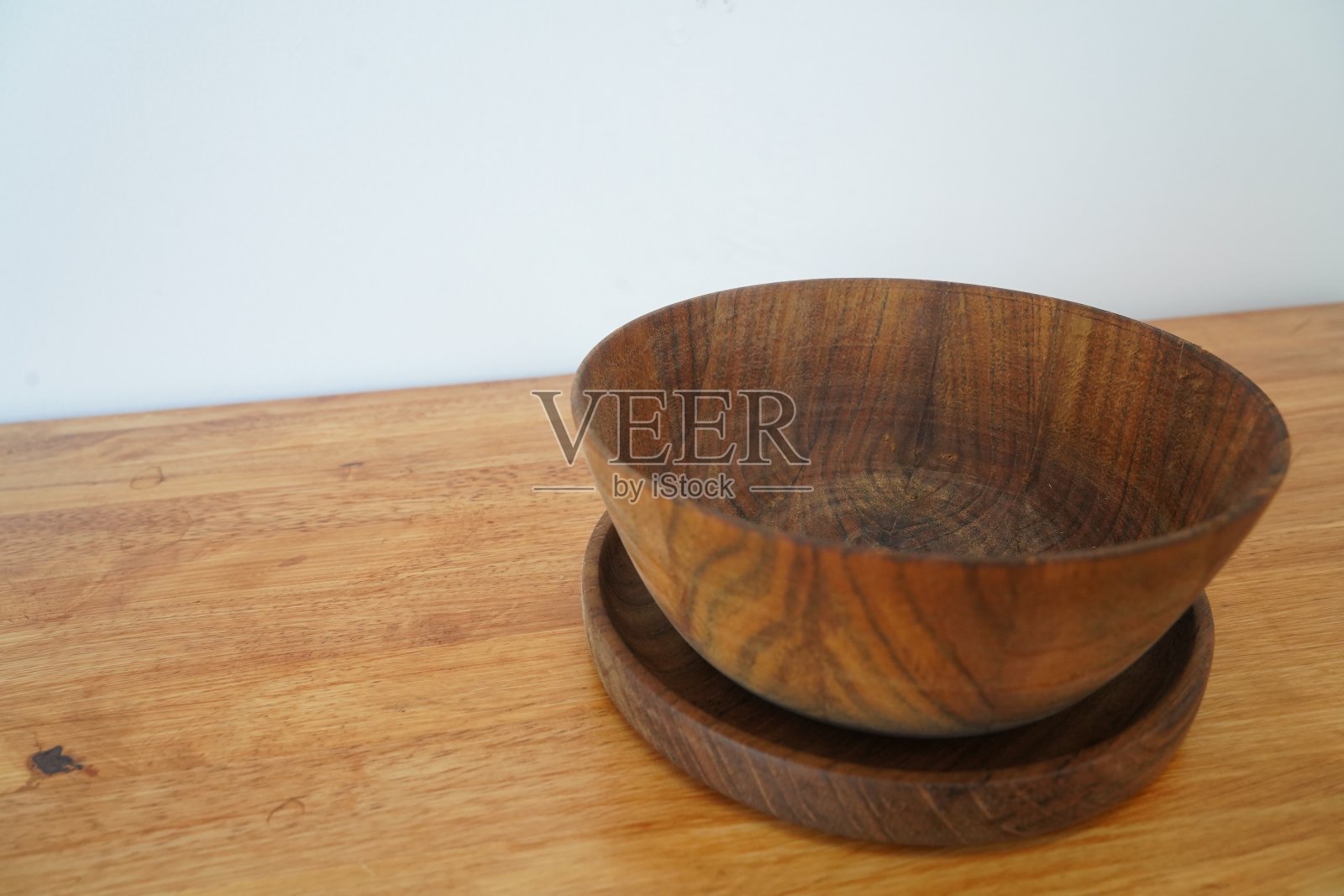 空的木碗或装饰性的木盘子和绝缘杯垫照片摄影图片