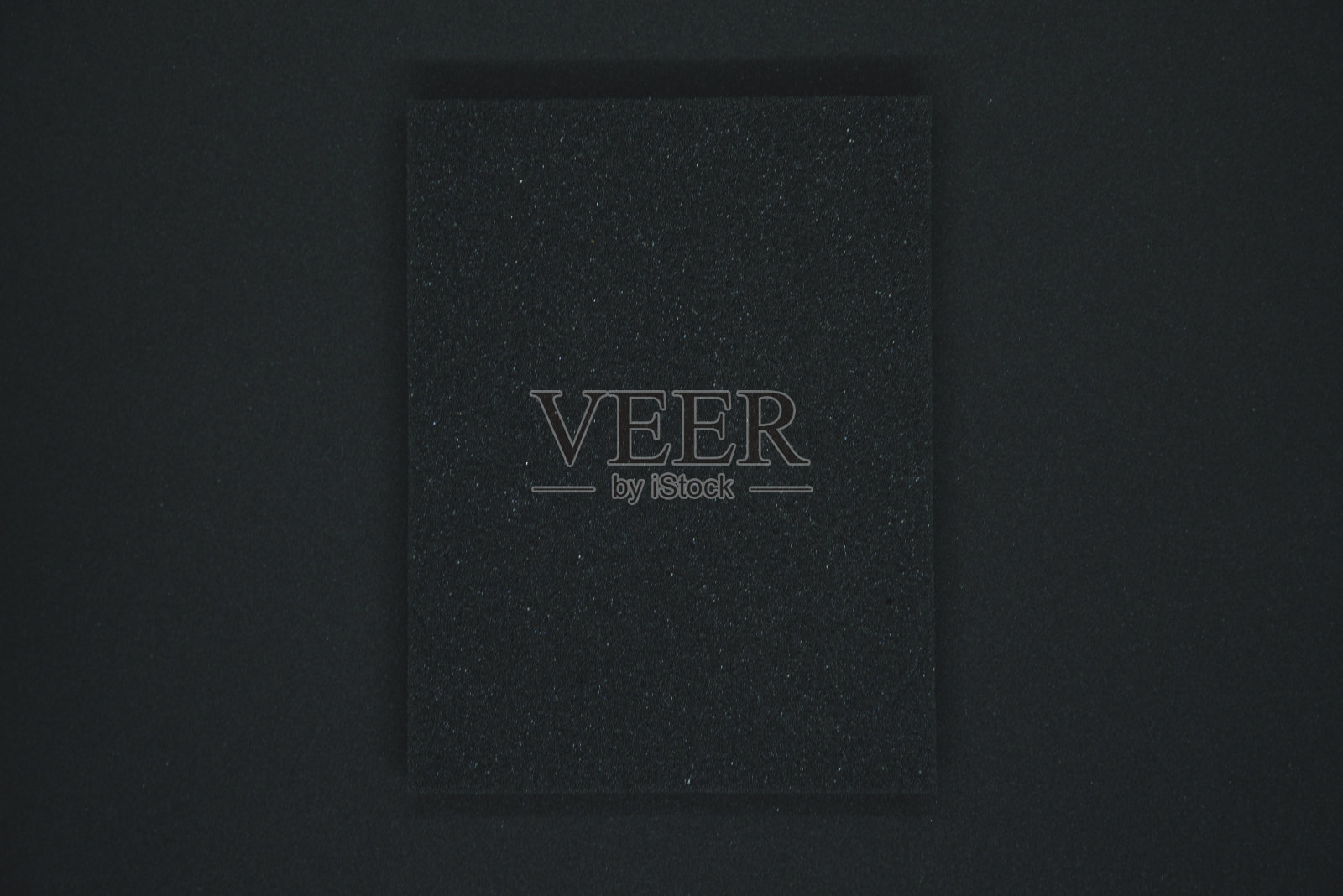 黑色背景上的黑色海绵。黑色泡沫橡胶在黑布上。垫片的黑色方形。照片摄影图片