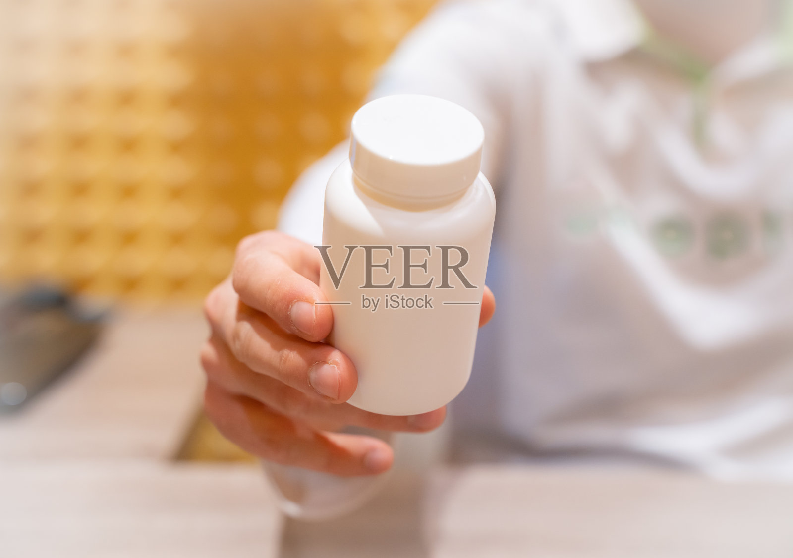 医生递给病人一瓶白色的药、药片、胶囊或维生素。照片摄影图片