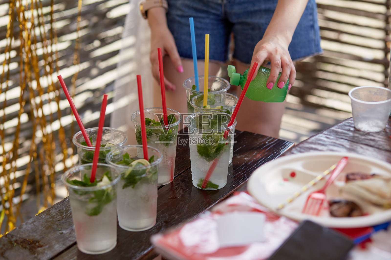 一名年轻女子在单身派对上为公司制作莫吉托鸡尾酒。准备指令。步骤2照片摄影图片