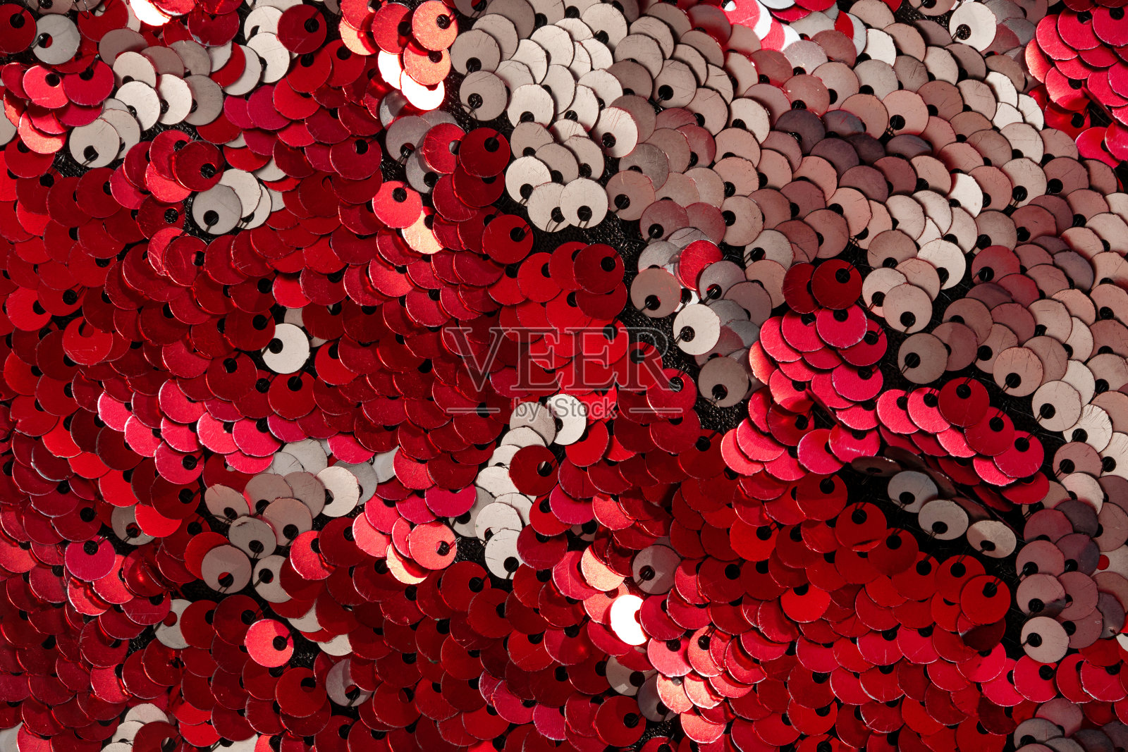 红色银色闪亮的亮片纹理背景衣服材料平铺。彩色闪光金属织物微距照片。照片摄影图片