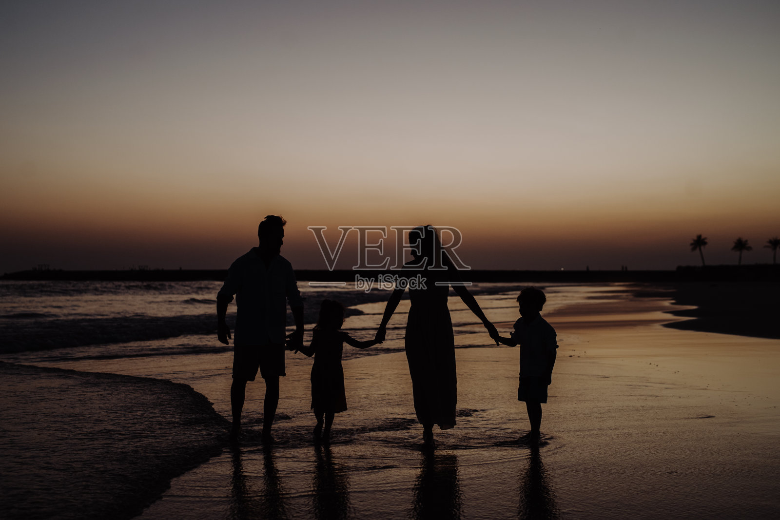 幸福家庭在异国享受海上日落照片摄影图片