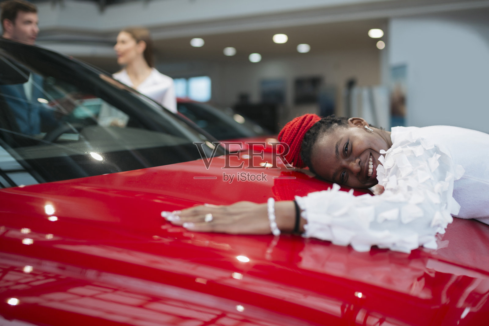 快乐的年轻女子给她的新车一个大大的拥抱照片摄影图片