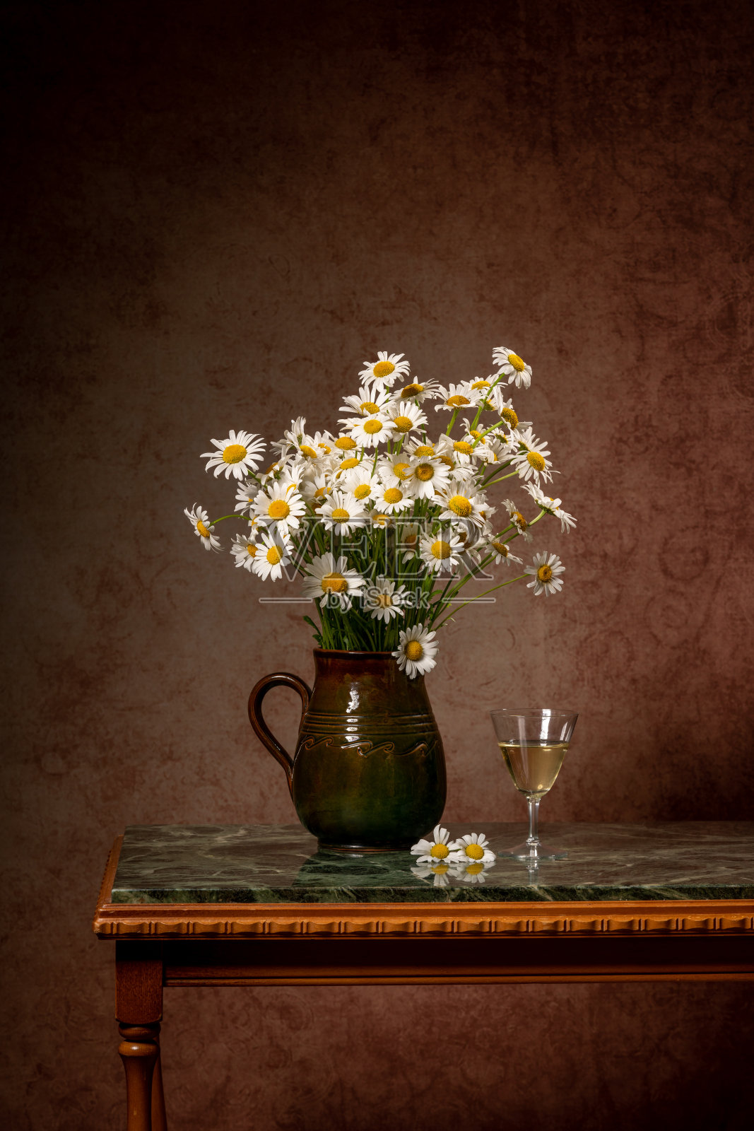 一束雏菊，旁边刻着爱和一杯白葡萄酒。静物画照片摄影图片