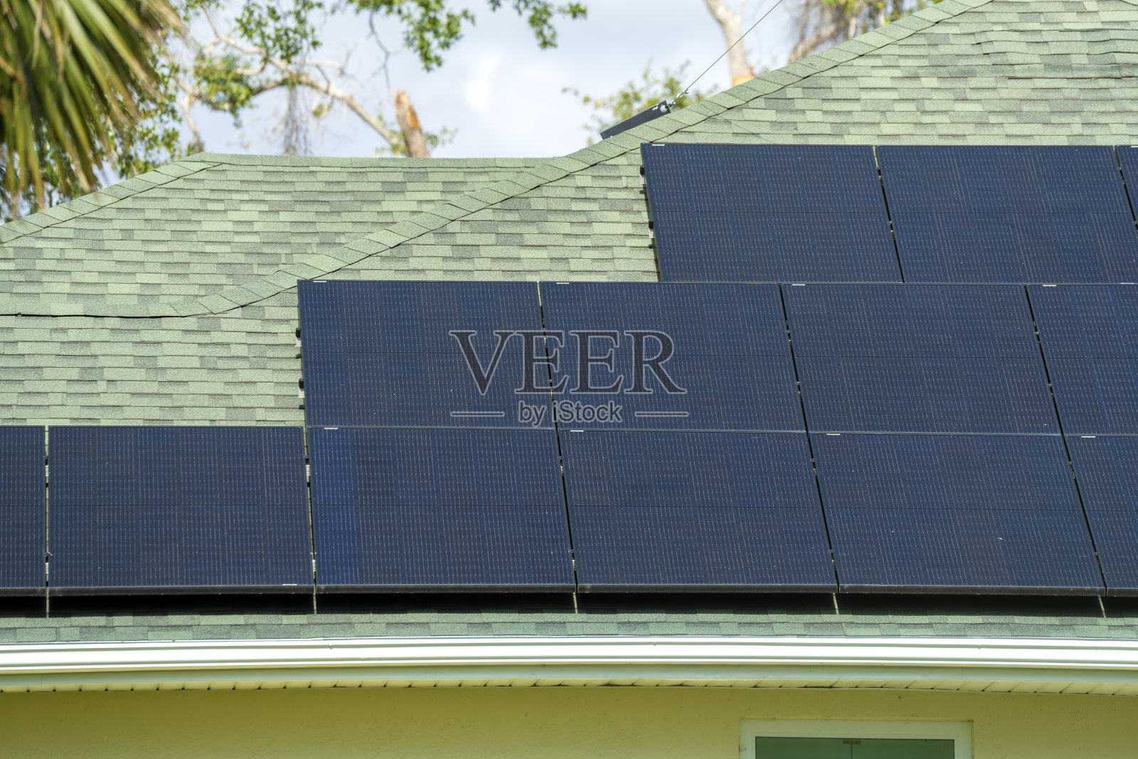 典型的美国建筑屋顶鸟瞰图，蓝色太阳能光伏板生产清洁生态电能。为退休收入投资可再生电力的概念照片摄影图片