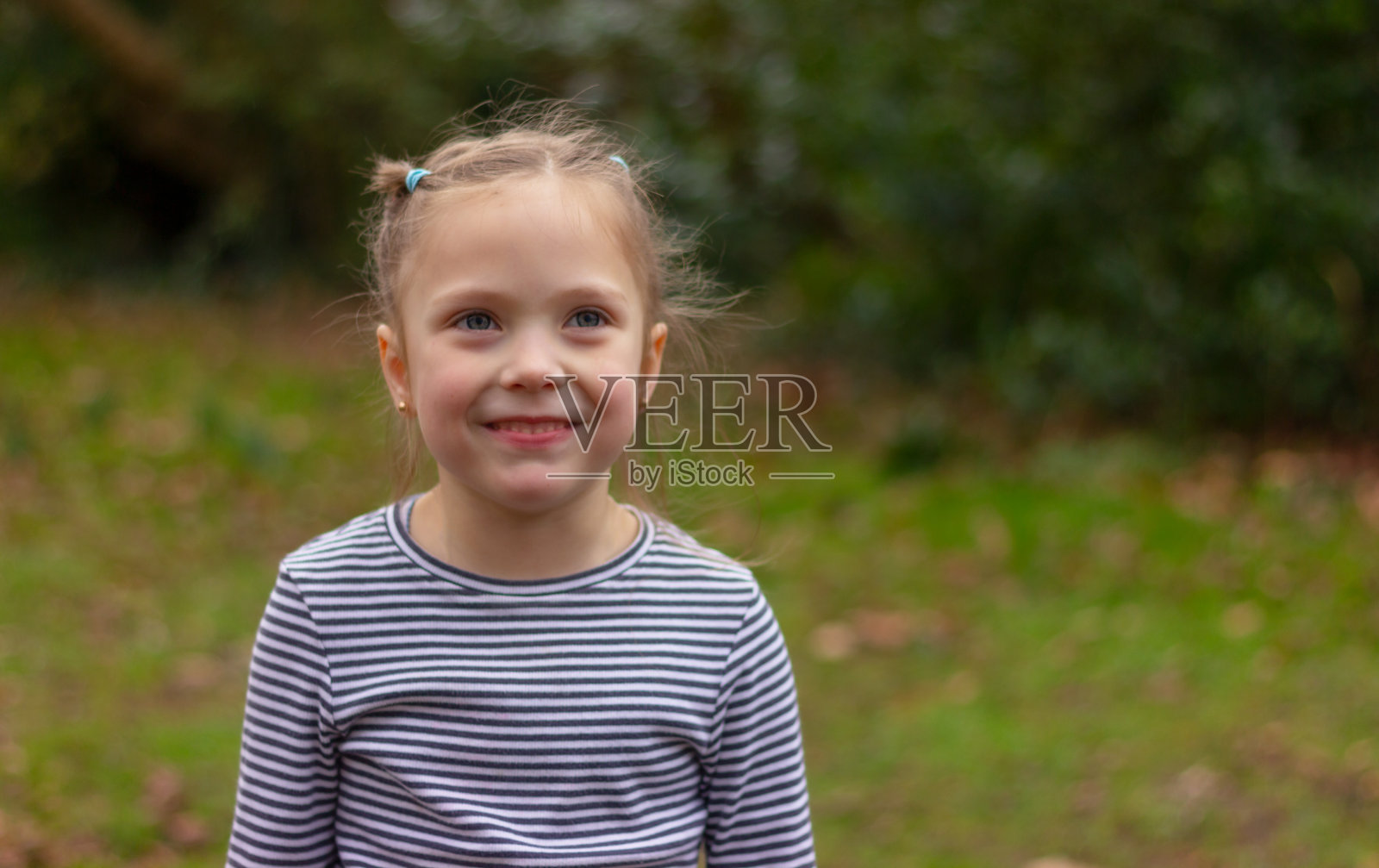 可爱的小女孩在公园里微笑的肖像。童年，欢乐，家庭。照片摄影图片