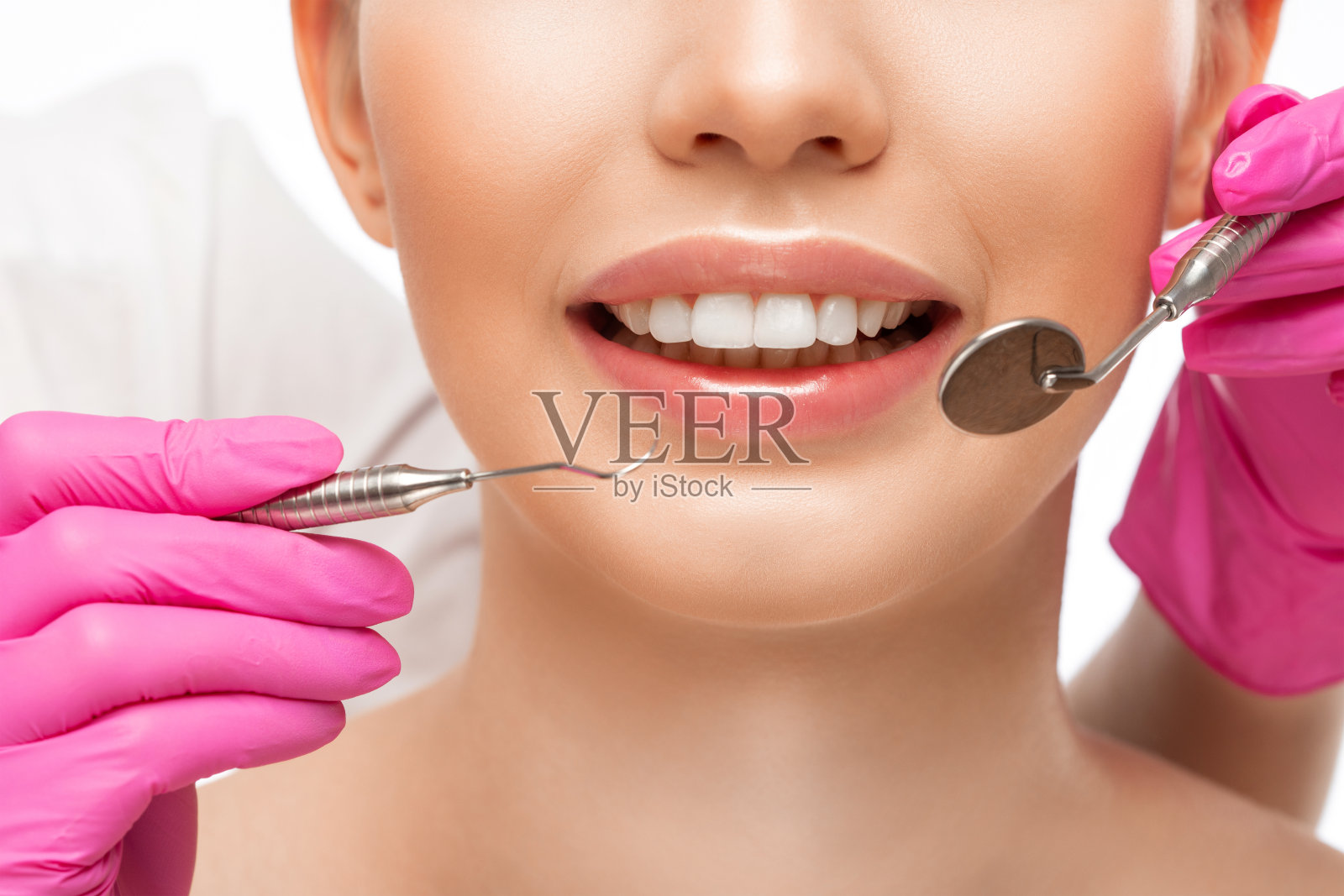 一位牙科医生在牙科诊所为一位年轻漂亮的女士治疗龋齿。牙齿充填。照片摄影图片