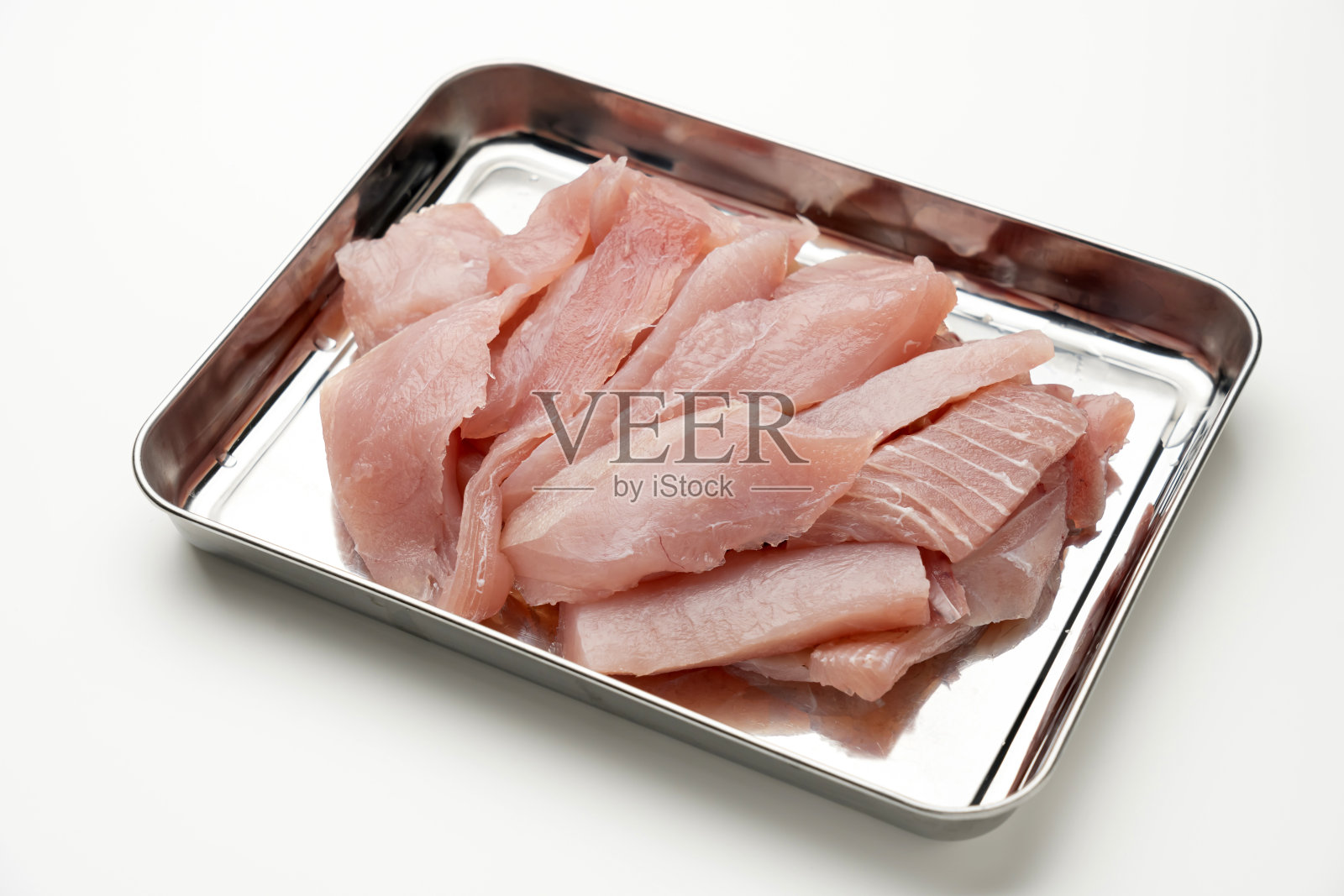 “Maguro no ara”生金枪鱼片在不锈钢托盘上的白色背景。照片摄影图片