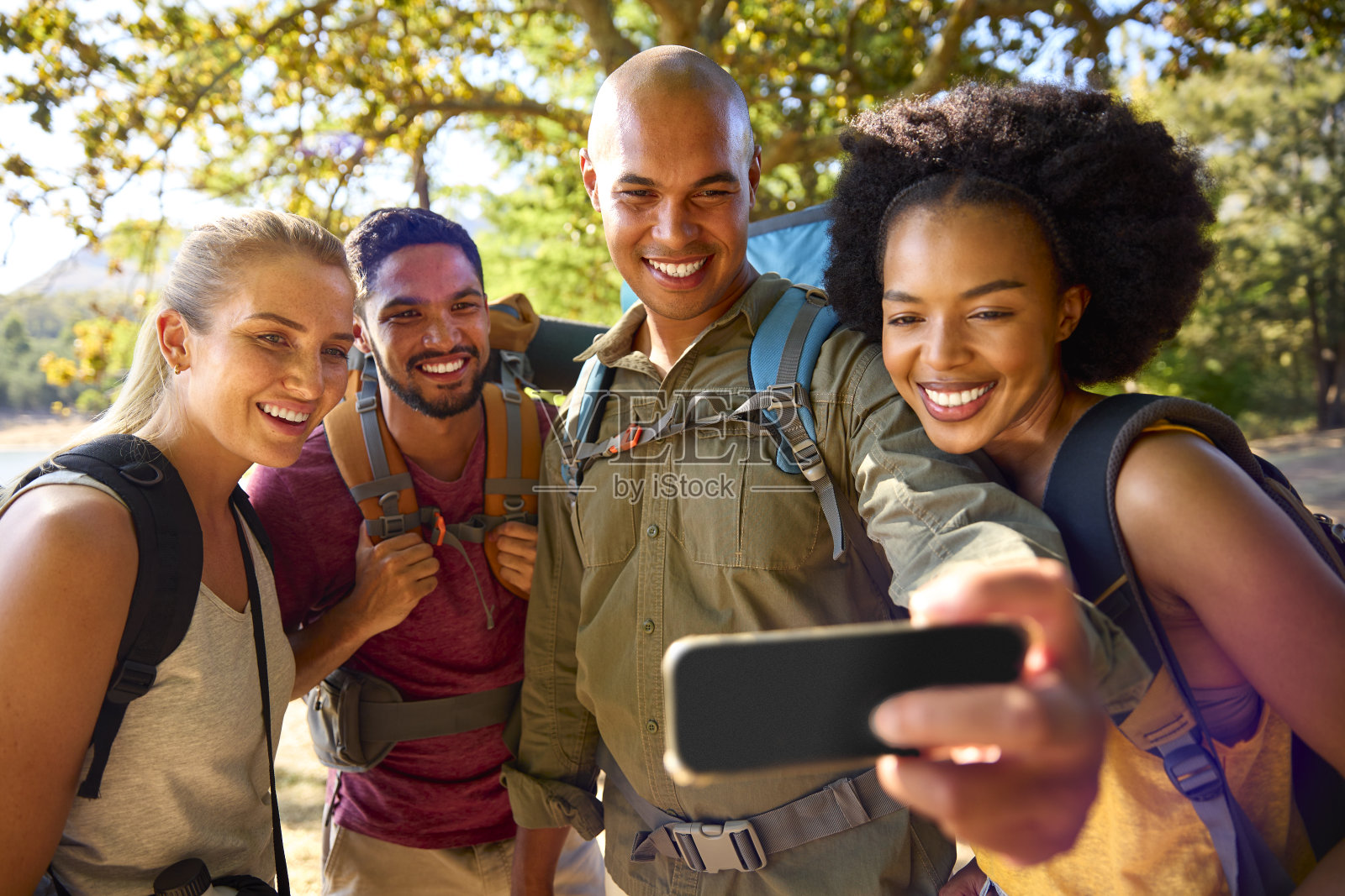 一群背着背包的朋友在乡村度假徒步旅行时用手机自拍照片摄影图片