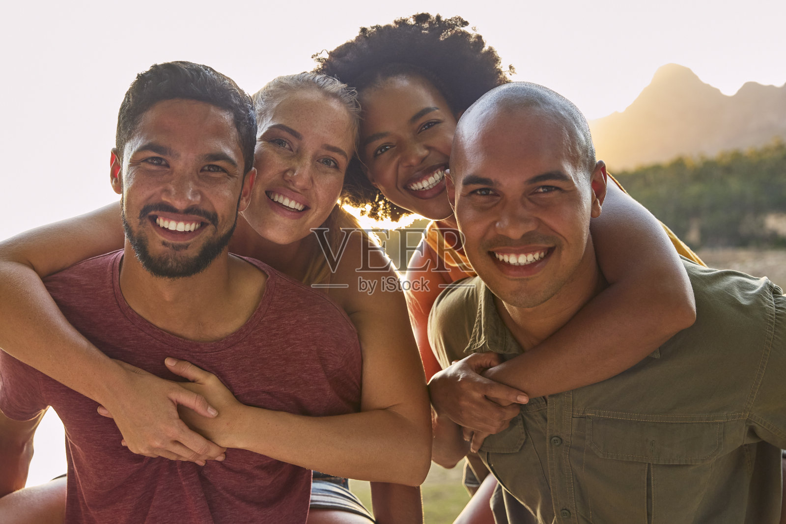 朋友们的户外肖像，男人给女人背带照片摄影图片