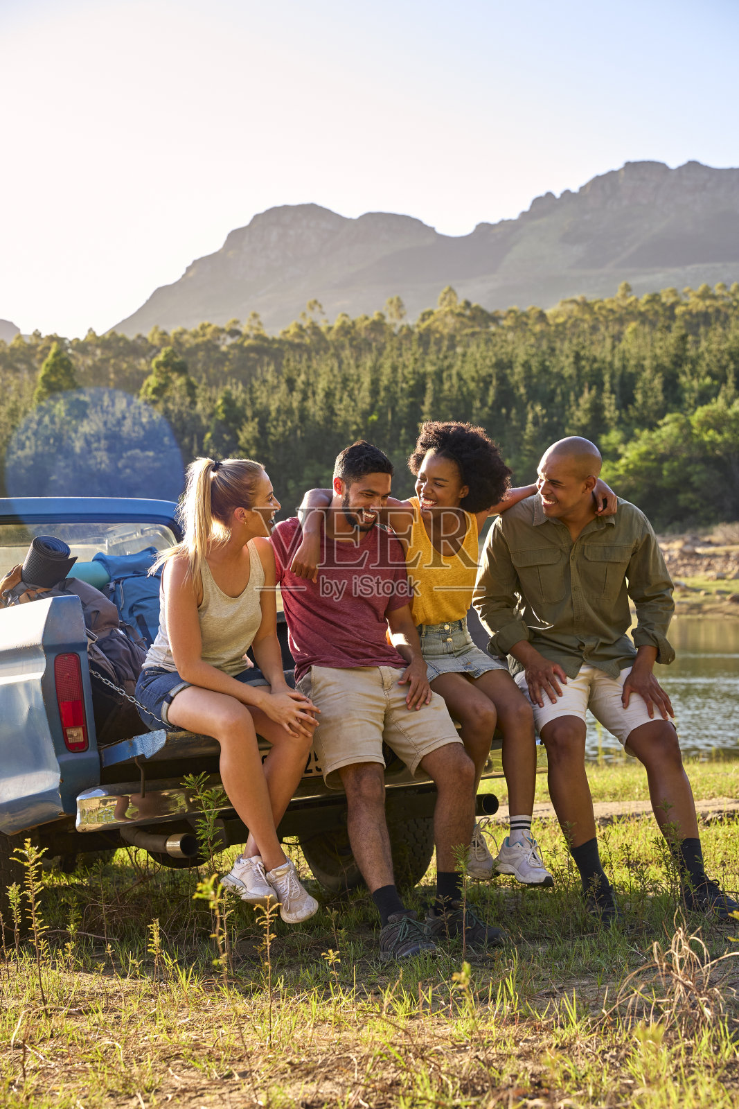 一群背着背包的朋友开着皮卡在湖边和山上自驾游照片摄影图片