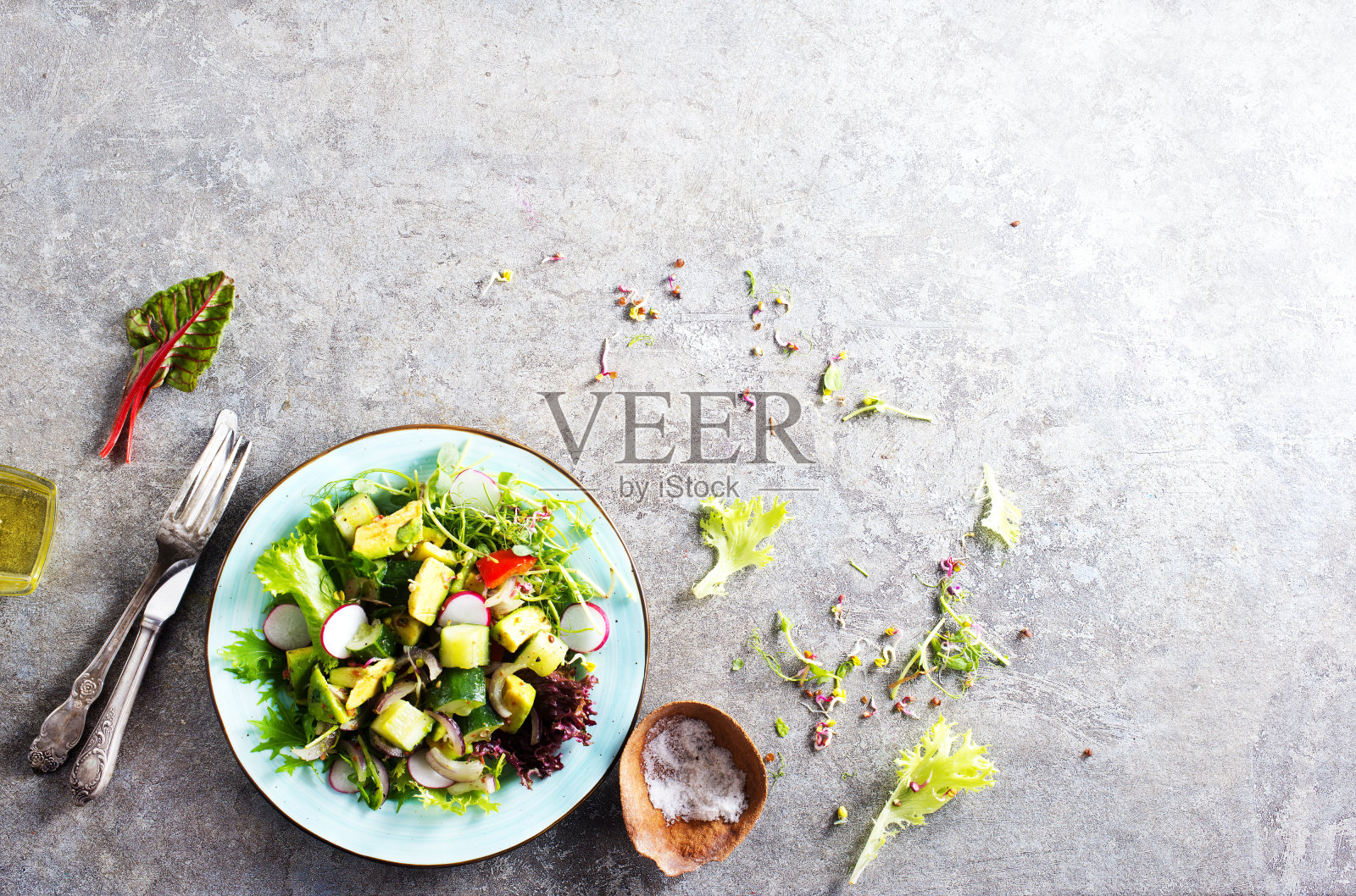 牛油果沙拉配黄瓜和其他蔬菜，放在一个蓝色的复古碗里照片摄影图片