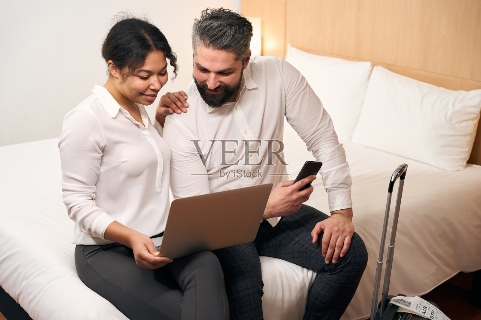 年轻的游客夫妇在酒店房间使用笔记本电脑照片摄影图片