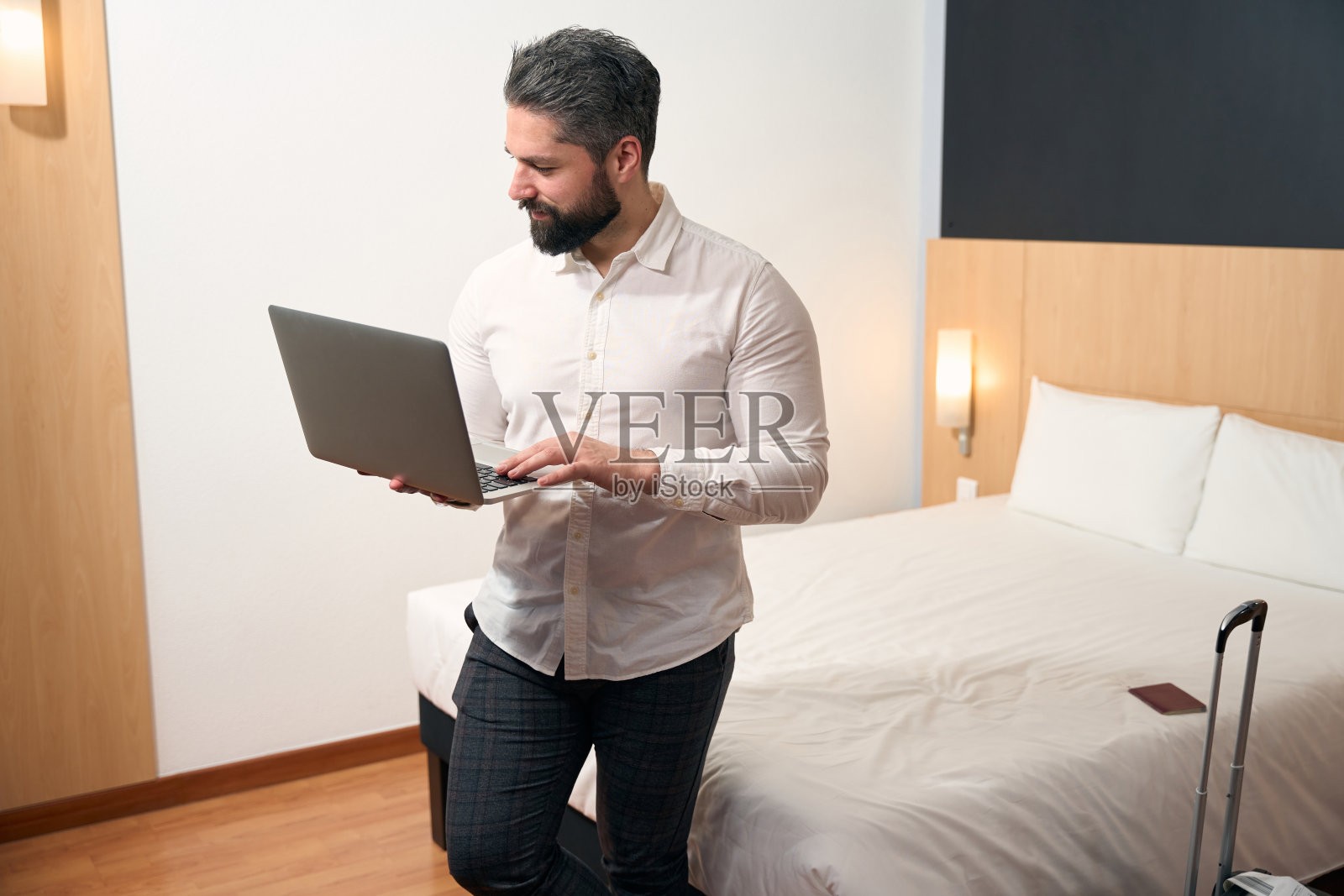 专注的商务人士在酒店房间的便携式电脑上打字照片摄影图片