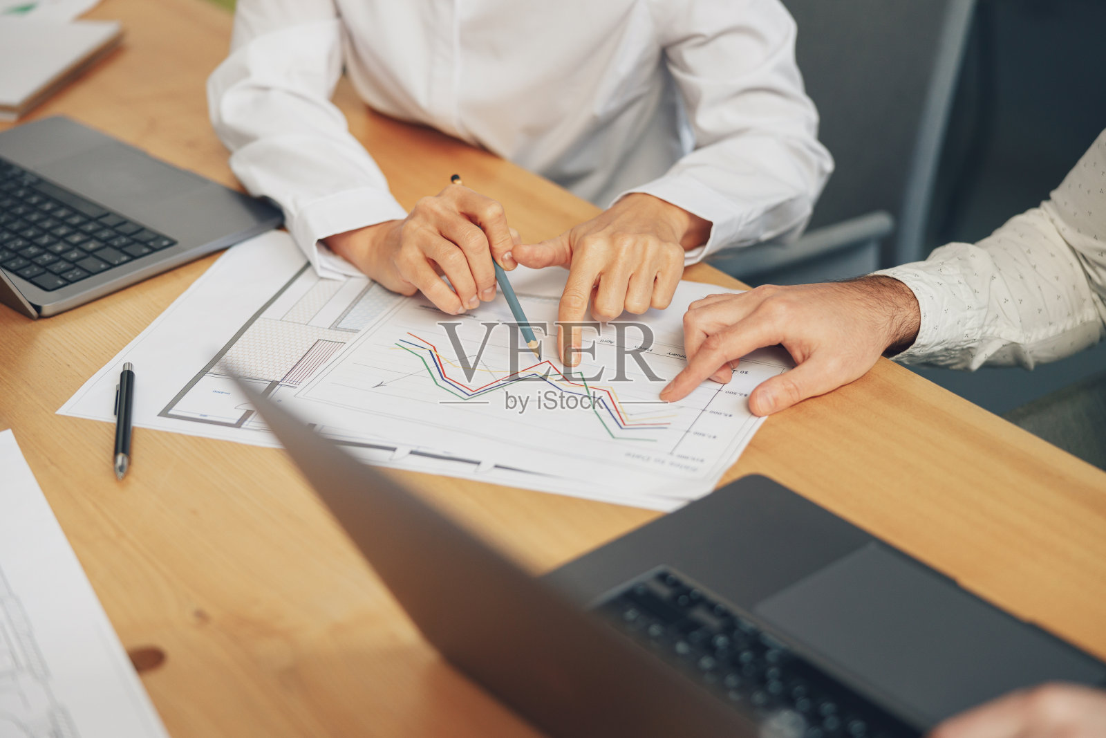 近距离的业务团队正在分析新的财务项目，同时在办公桌上一起工作照片摄影图片