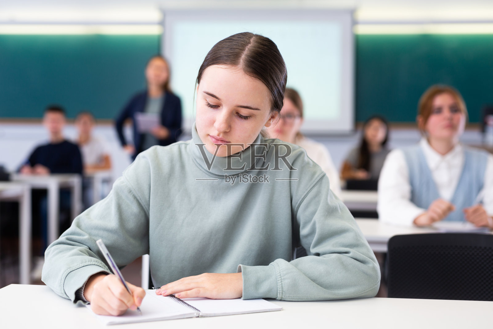 一群学生拿着笔和笔记本在教室里学习照片摄影图片