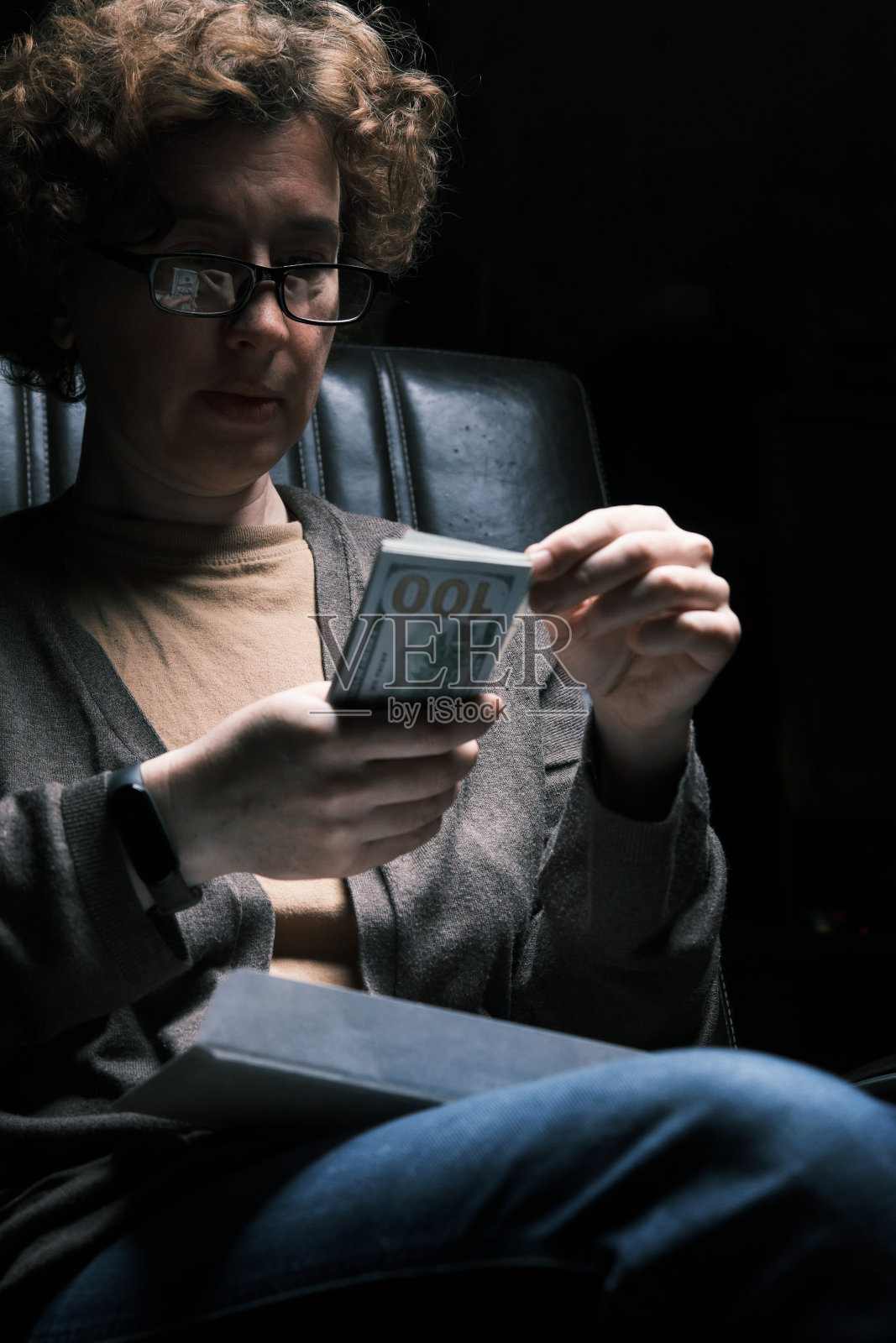 一个成熟的女人正在数一叠纸币照片摄影图片