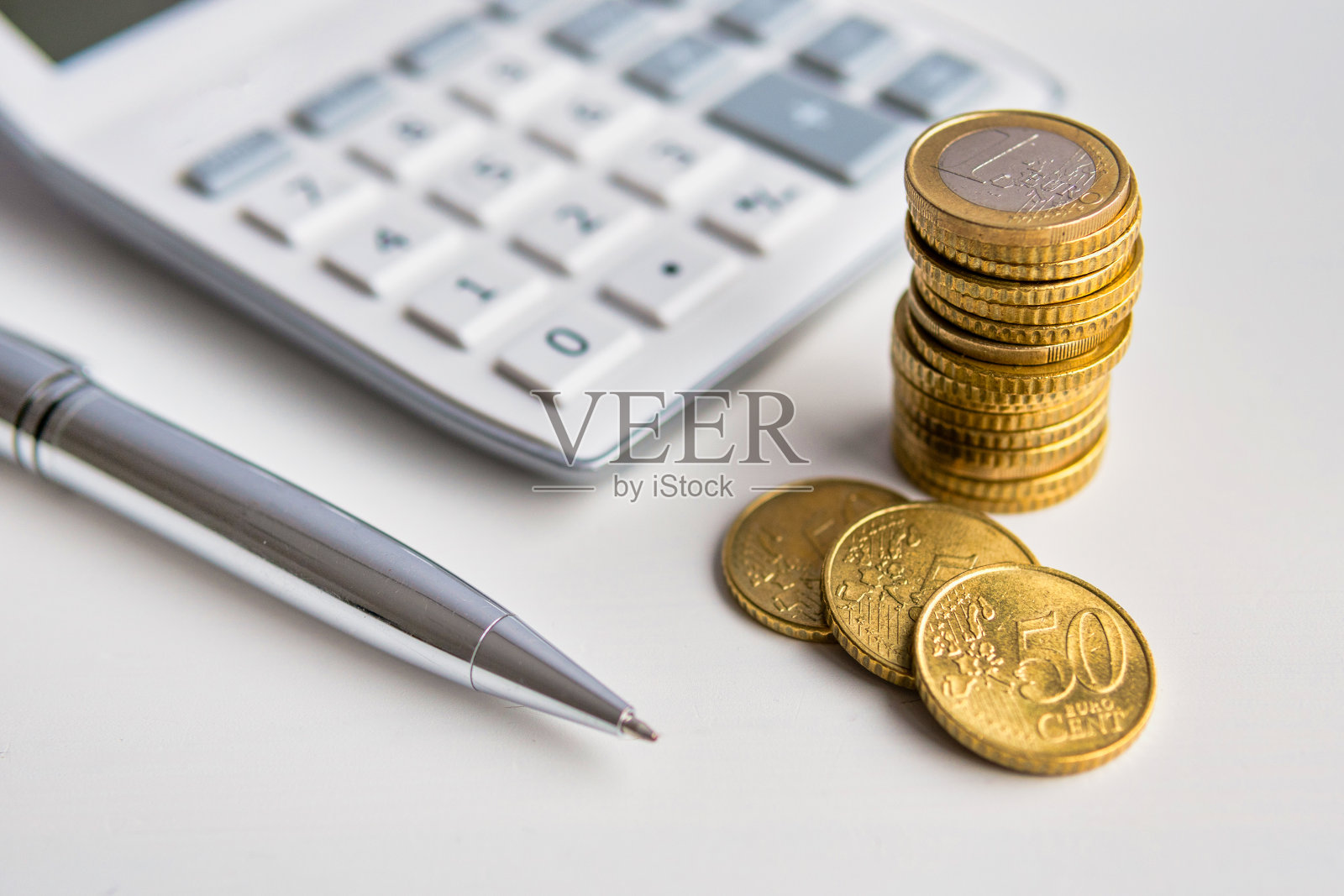 计算器，欧元硬币和一支笔照片摄影图片