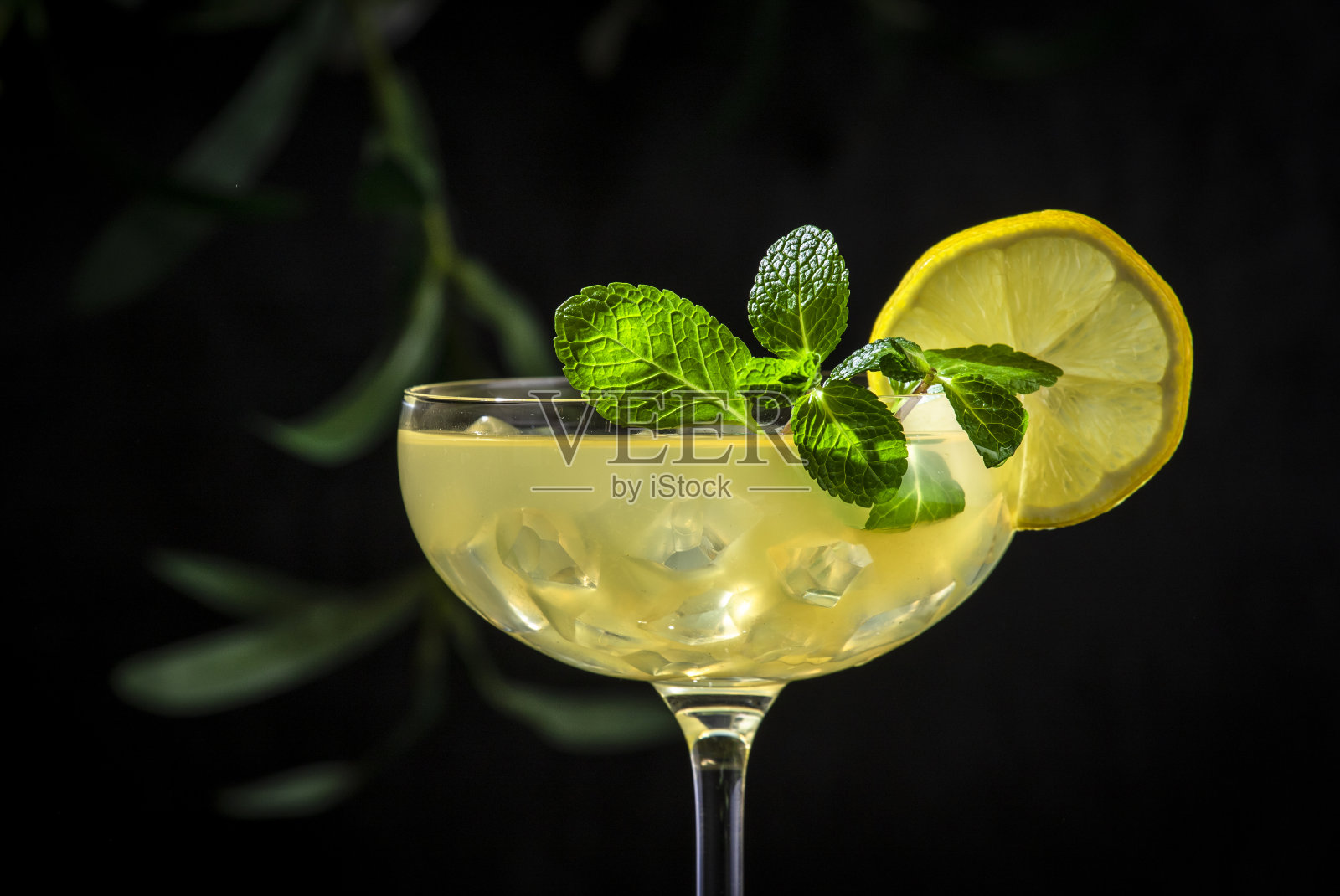 用干杜松子酒、烈酒、柠檬汁和冰块调制的白女士鸡尾酒。黑色背景，特写照片摄影图片