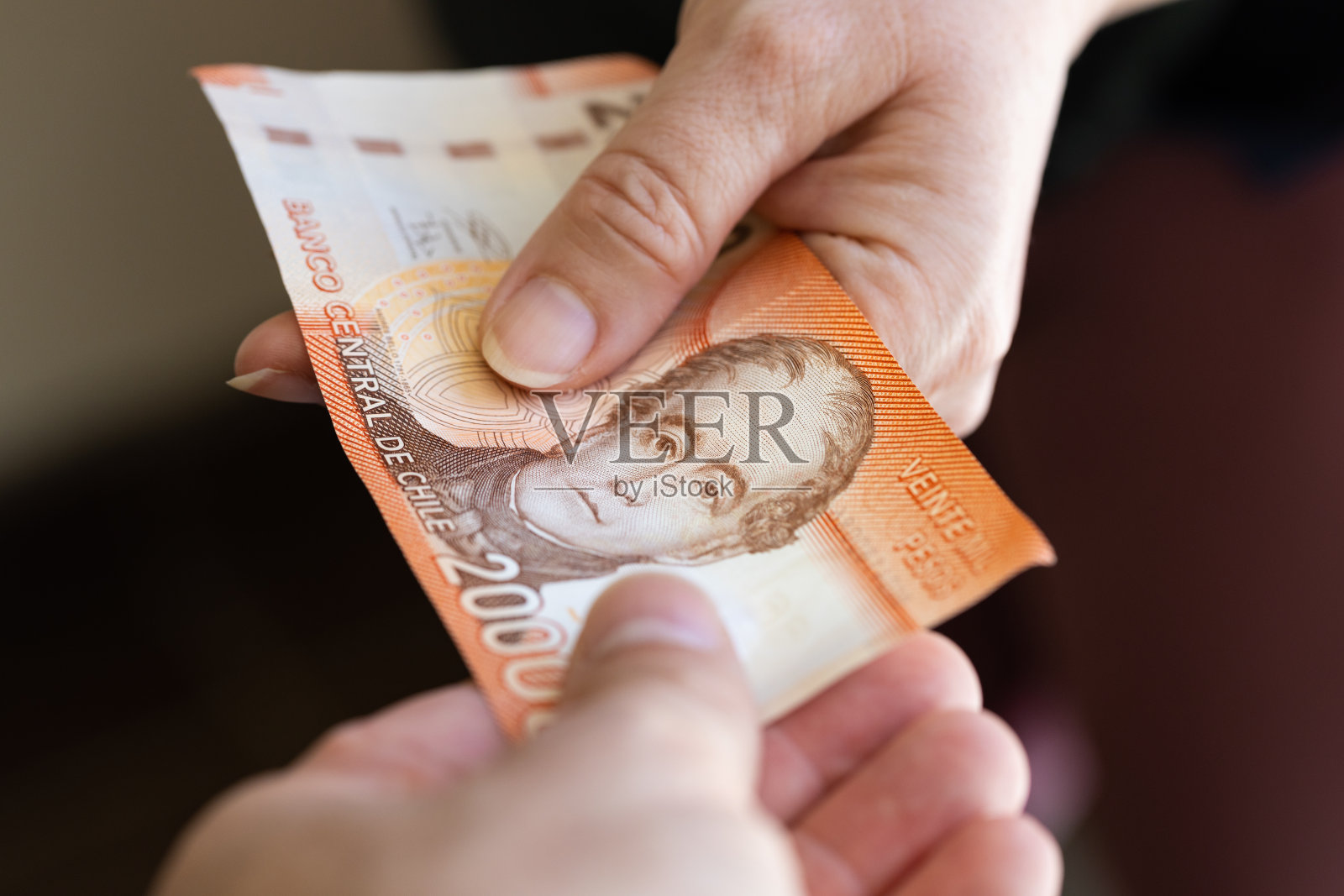 智利2万比索，纸币，手手相传，金融和商业概念，智利最高面额纸币，互相传递现金照片摄影图片