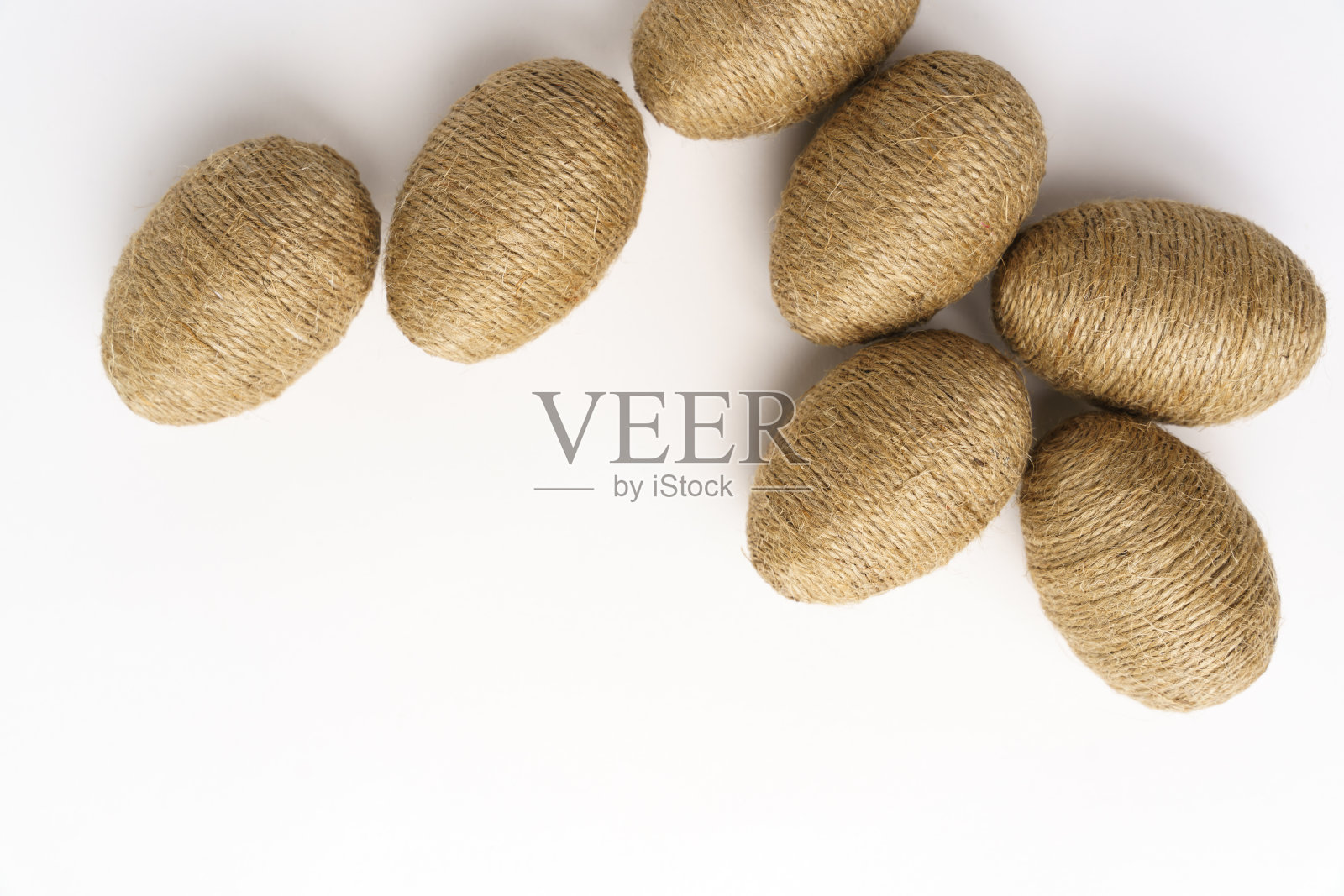 用黄麻麻绳手工包裹复活节彩蛋，孤立的白色背景。照片摄影图片