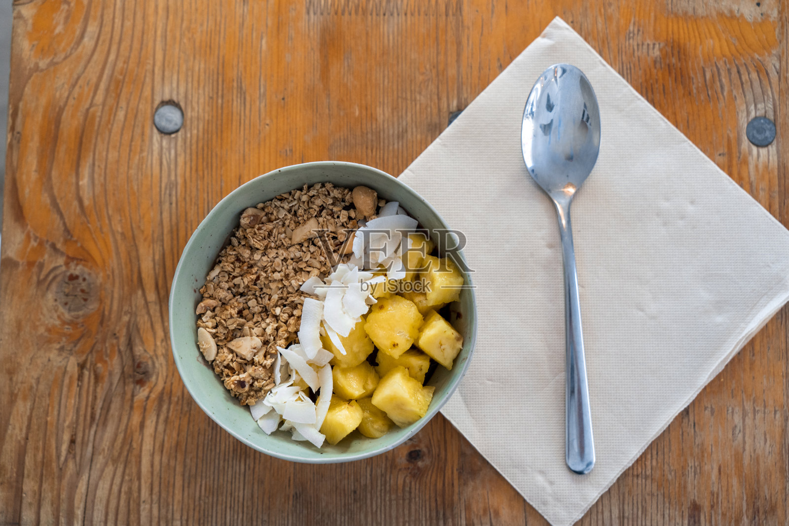 Top view of typical brazilian açaí bowl with cereals, coconut and pineapple照片摄影图片