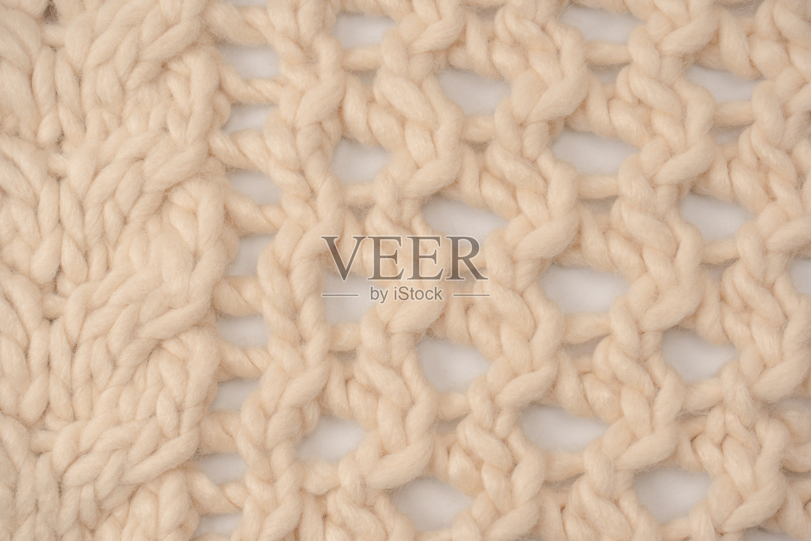 一块米色针织织物，由白色羊毛编织而成。照片摄影图片