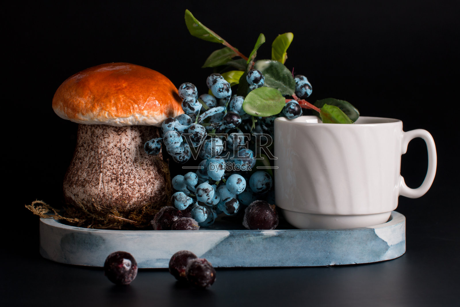 蓝莓放在黑色背景的盘子里。夏日静物与牛肝菌和浆果照片摄影图片