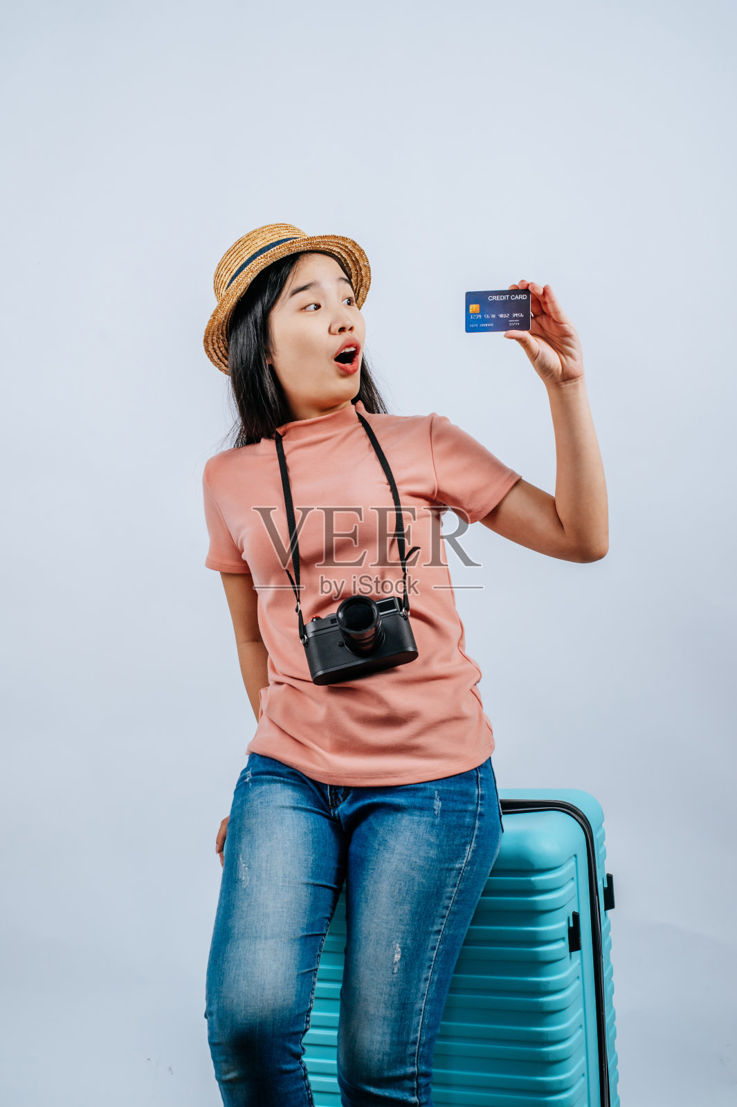 年轻美丽的旅行者女性摆出行李箱和信用卡照片摄影图片