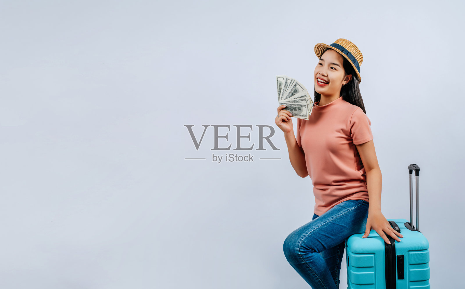 年轻美丽的旅行者女性摆出行李箱和钞票照片摄影图片