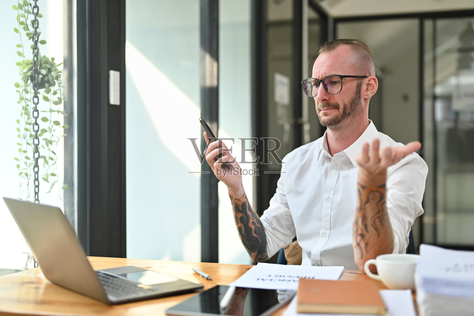 沮丧的男子看着手机屏幕，对网络连接速度或低信号设备问题感到恼火。照片摄影图片