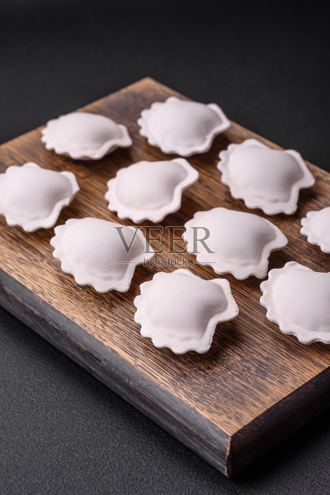 生的冷冻饺子放在木砧板上照片摄影图片