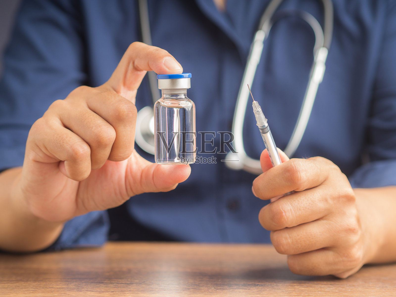 一名医生正拿着疫苗瓶和注射器。预防和治疗病毒感染的疫苗。照片摄影图片