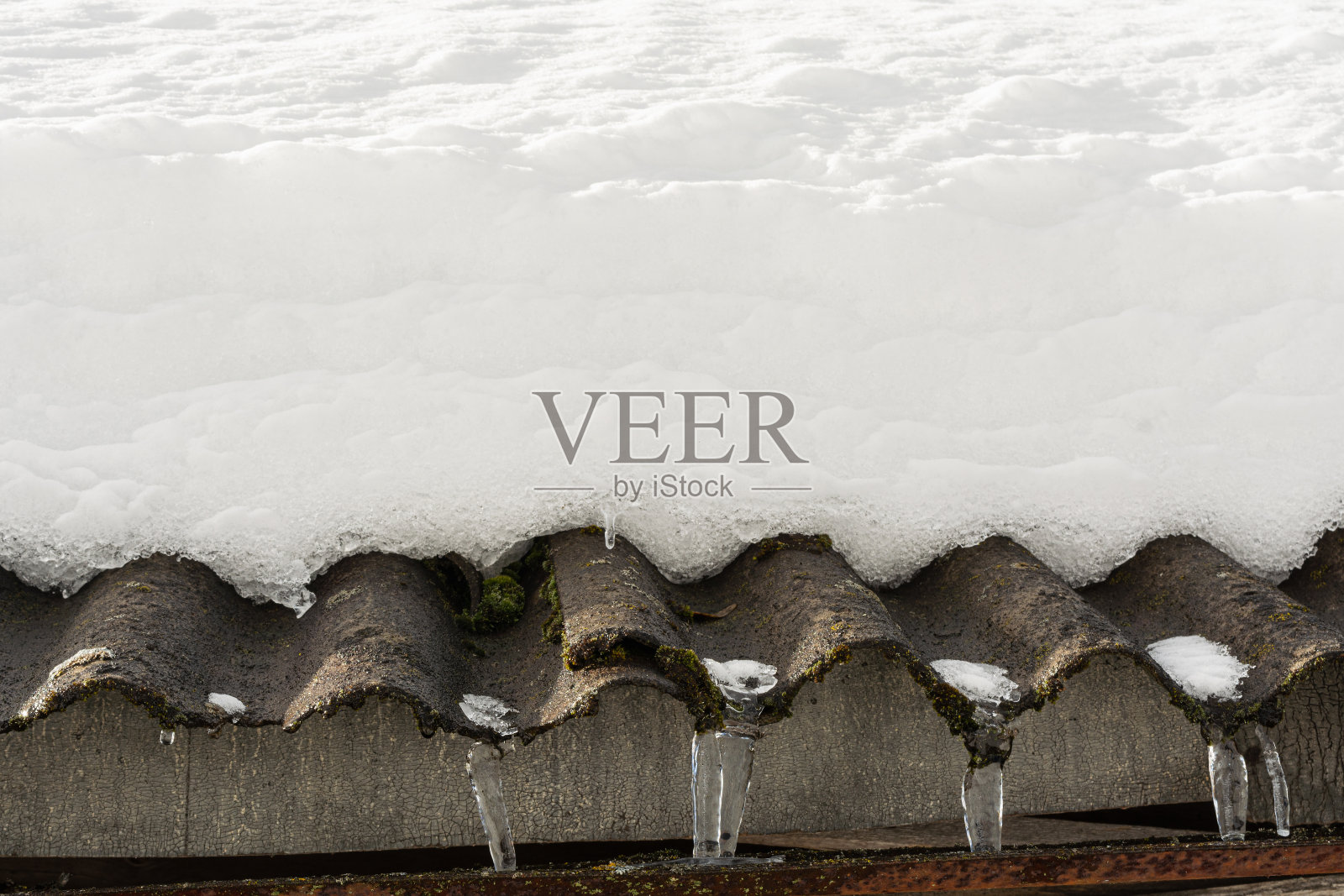 春天太多的雪会融化在石板屋顶上照片摄影图片