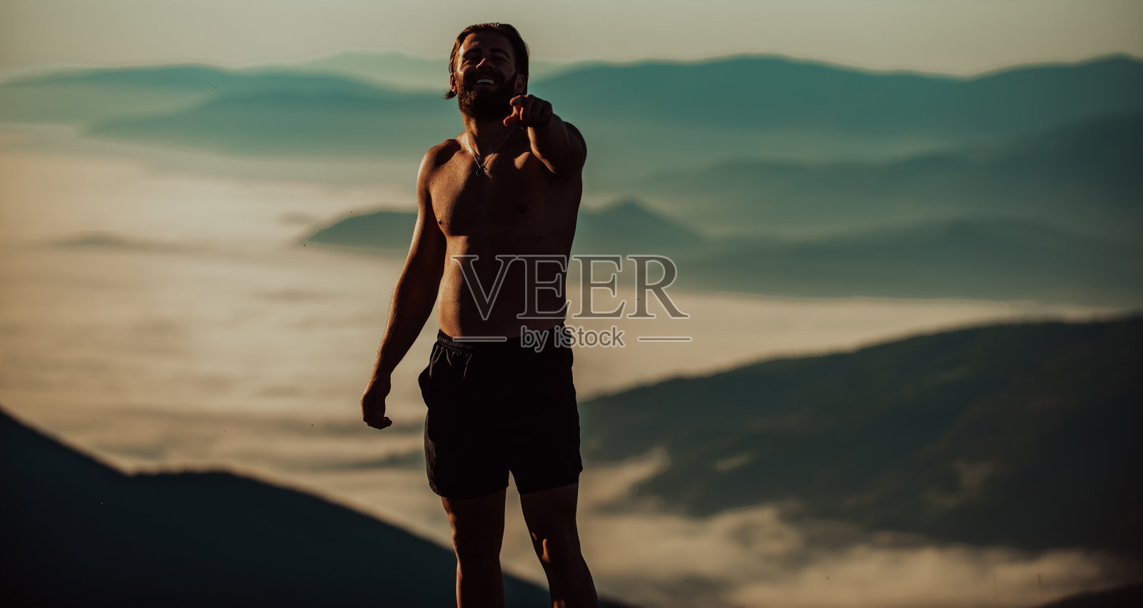 一名运动员在疲惫的跑步训练后在山顶休息。照片摄影图片