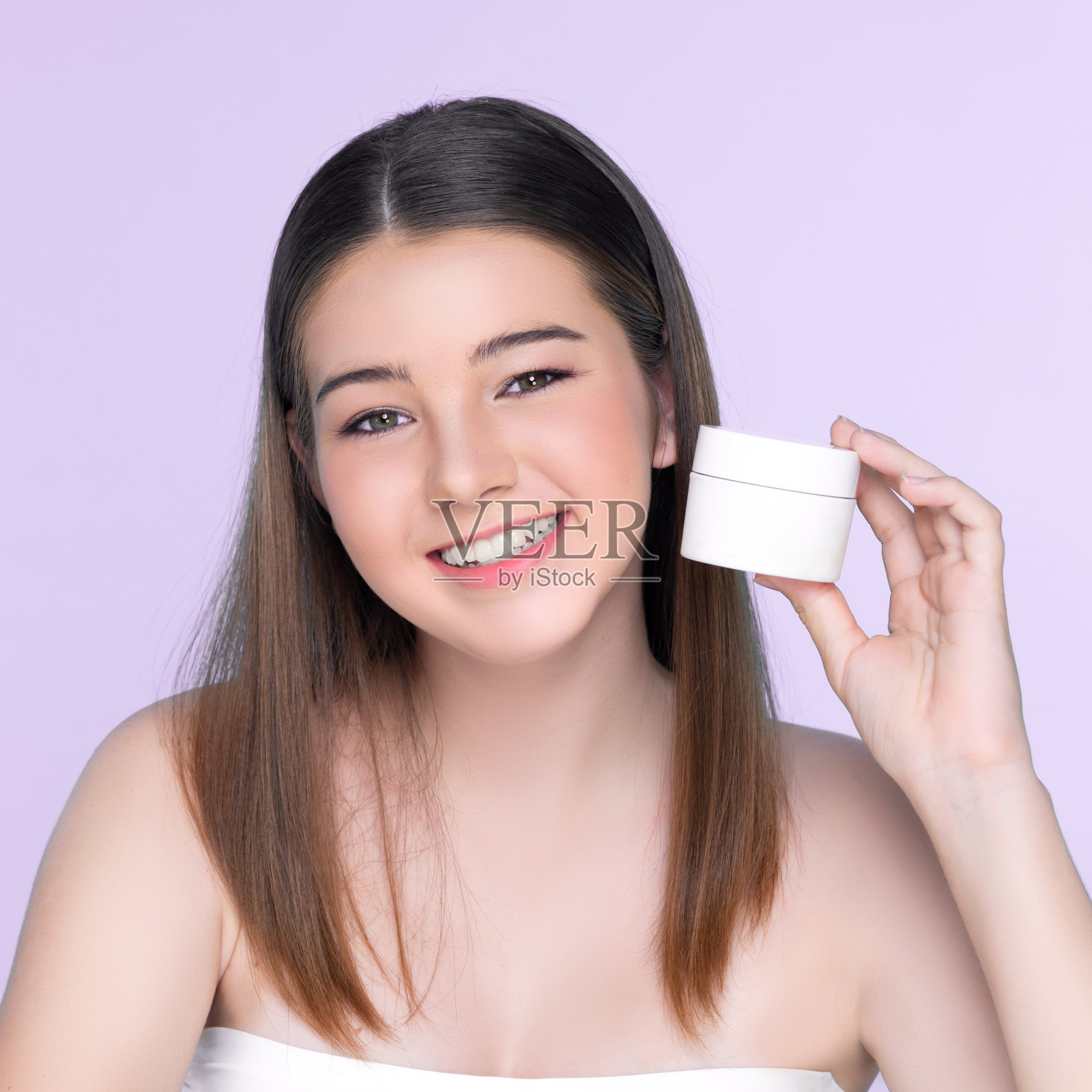 年轻迷人的女孩与自然的美丽抱乳液罐。照片摄影图片